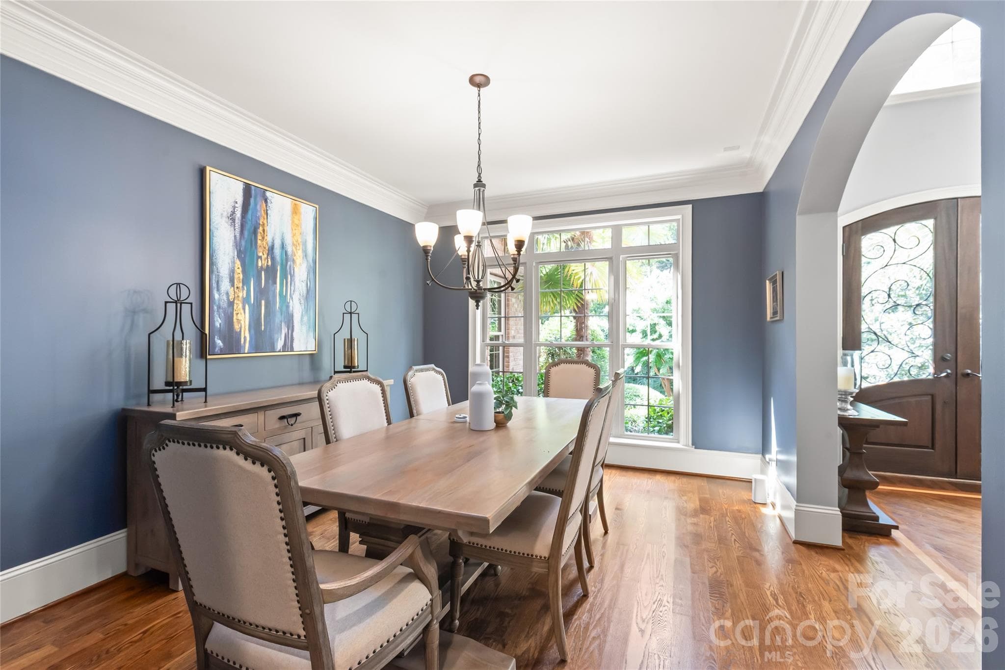An arched entry welcomes you into a formal dining room defined by heavy molding and rich hardwood floors. - 7320 Summerlin Place, Charlotte