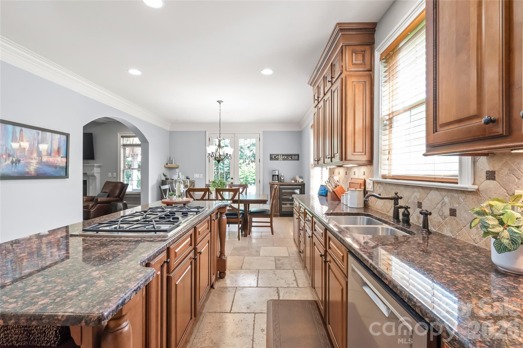 A sleek gas cooktop with an integrated downdraft system blends professional performance with clean, open lines. - 7320 Summerlin Place, Charlotte