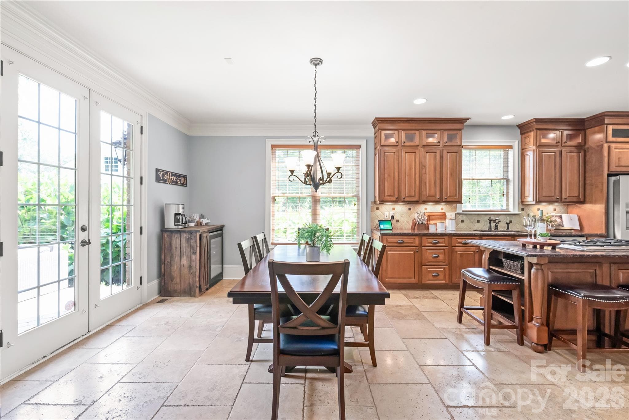 Heavy crown molding frames the space, while 8-foot French doors open out onto a private backyard. - 7320 Summerlin Place, Charlotte