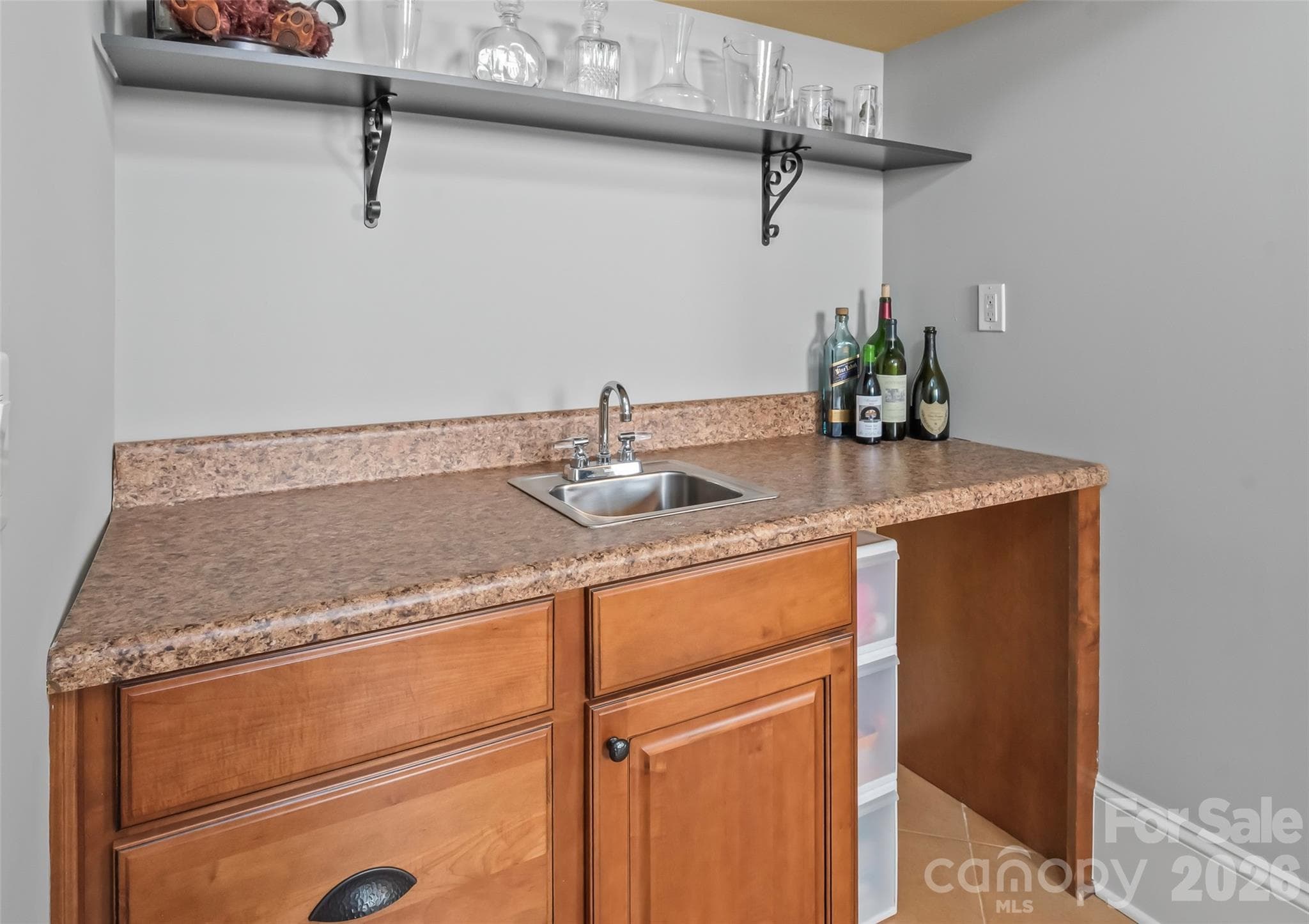 A wet bar turns this main-level fifth bedroom or playroom into the ultimate self-contained suite for guests, hosting, or relaxing. - 7320 Summerlin Place, Charlotte