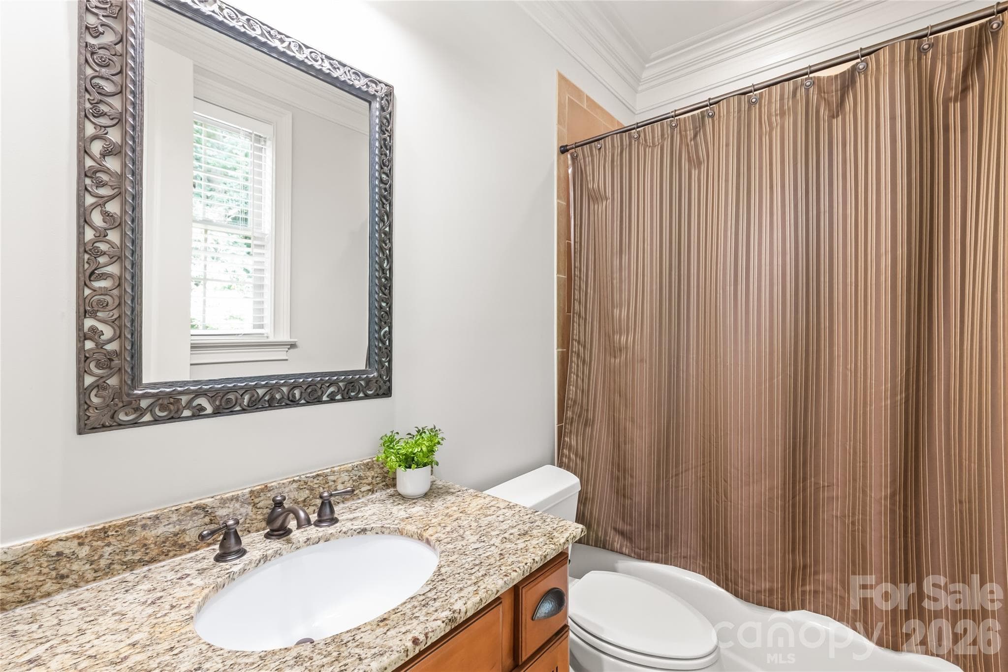 A fully dedicated bathroom directly serves the main level bedroom, providing ultimate privacy and convenience for guests. - 7320 Summerlin Place, Charlotte