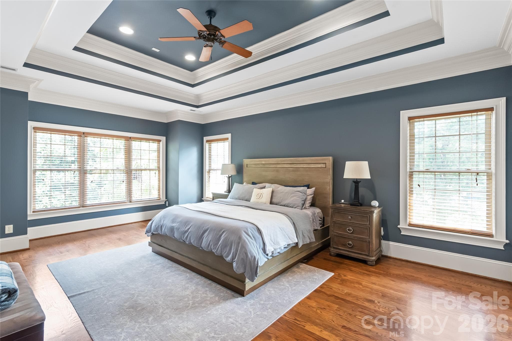The primary suite features elegant double trey ceilings, detailed heavy crown molding, and beautiful hardwood floors throughout. - 7320 Summerlin Place, Charlotte