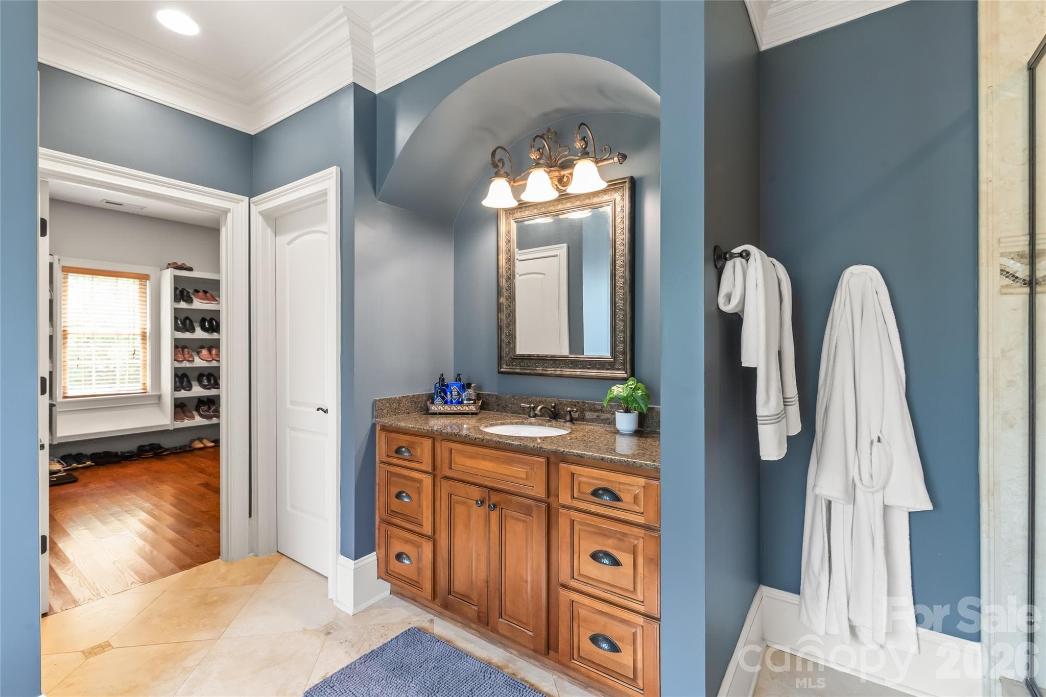 The primary en-suite features dual separate vanities, a deep soaking tub, a walk-in shower, and high-profile baseboards for a classic finish. - 7320 Summerlin Place, Charlotte