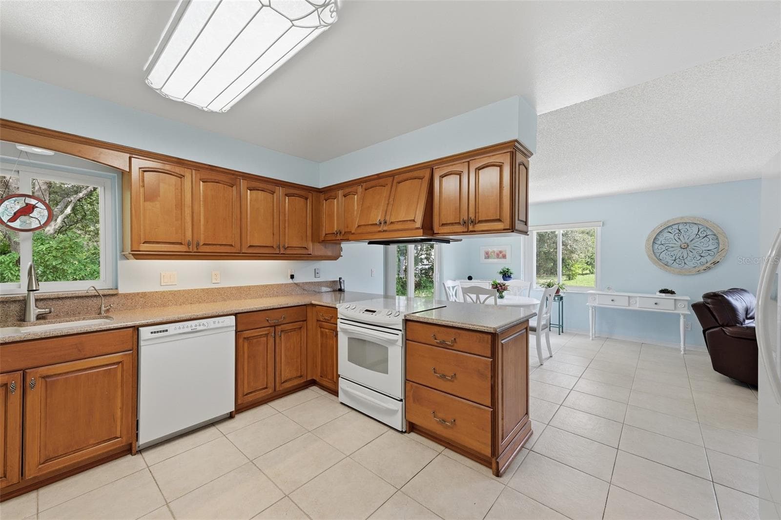 KITCHEN WITH WINDOW LOOKING OUT TO THE WOODS AND INTO THE FAMILY ROOM BREAKFAST NOOK - 1803 NEW BEDFORD DR, SUN CITY CENTER