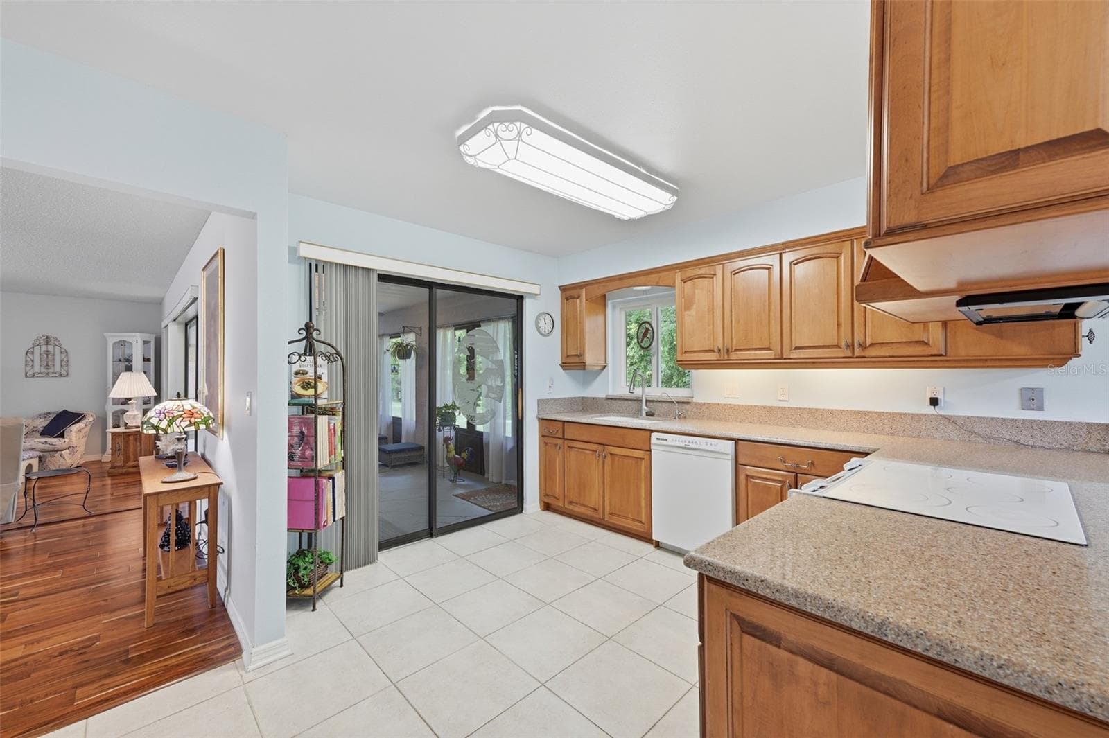 KITCHEN LOOKING OUT TO THE GLASS ENCLOSED LANAI AND GREAT ROOM. - 1803 NEW BEDFORD DR, SUN CITY CENTER