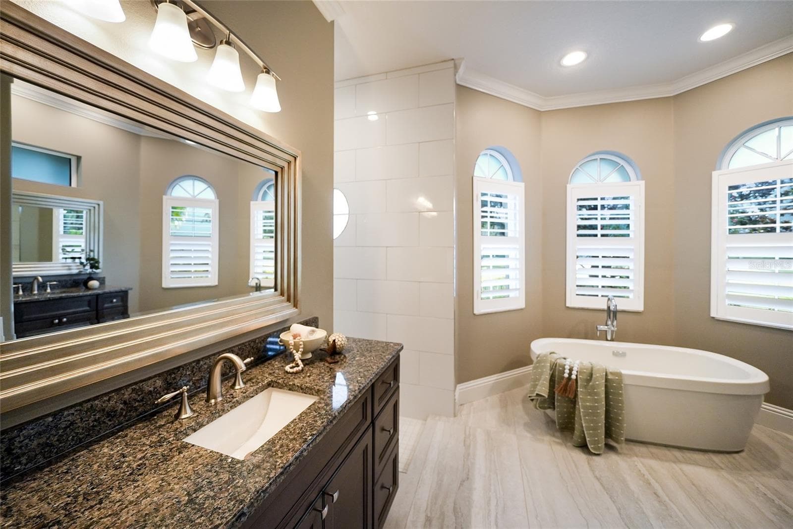 Remodeled luxury spa-like bath with two  vanities, large tub, and an separate shower - 8122 LONE TREE GLN, LAKEWOOD RANCH
