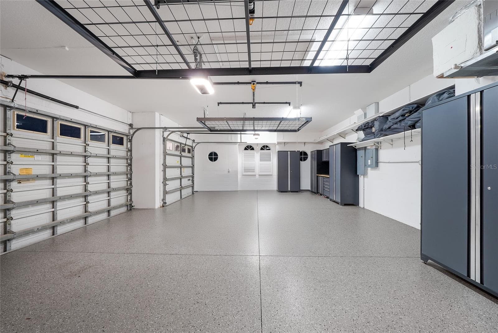 A side-load oversized and deep 3 car garage with new epoxy flooring, ceiling racks and cabinetry - 8122 LONE TREE GLN, LAKEWOOD RANCH