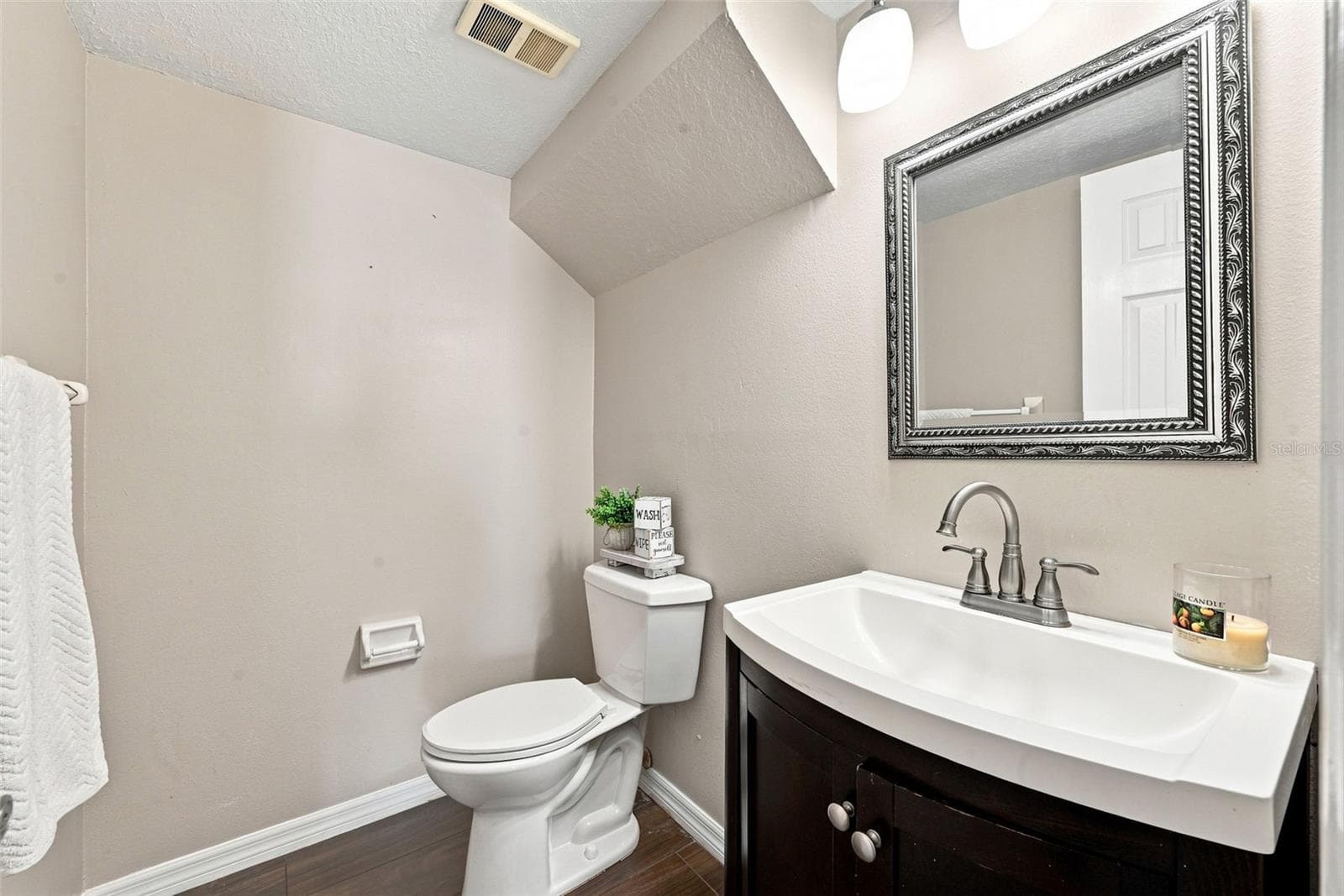 Convenient Guest Half Bath located beneath the staircase with updated vanity and finishes. - 1349 VALLEY PINE CIR, APOPKA
