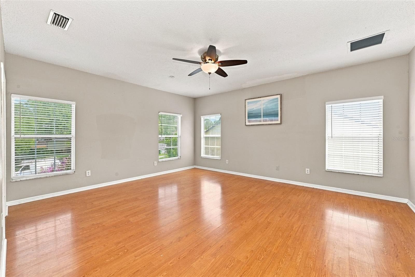 Expansive Primary Suite offers generous space, abundant natural light, and multiple windows overlooking the surrounding property. - 1349 VALLEY PINE CIR, APOPKA