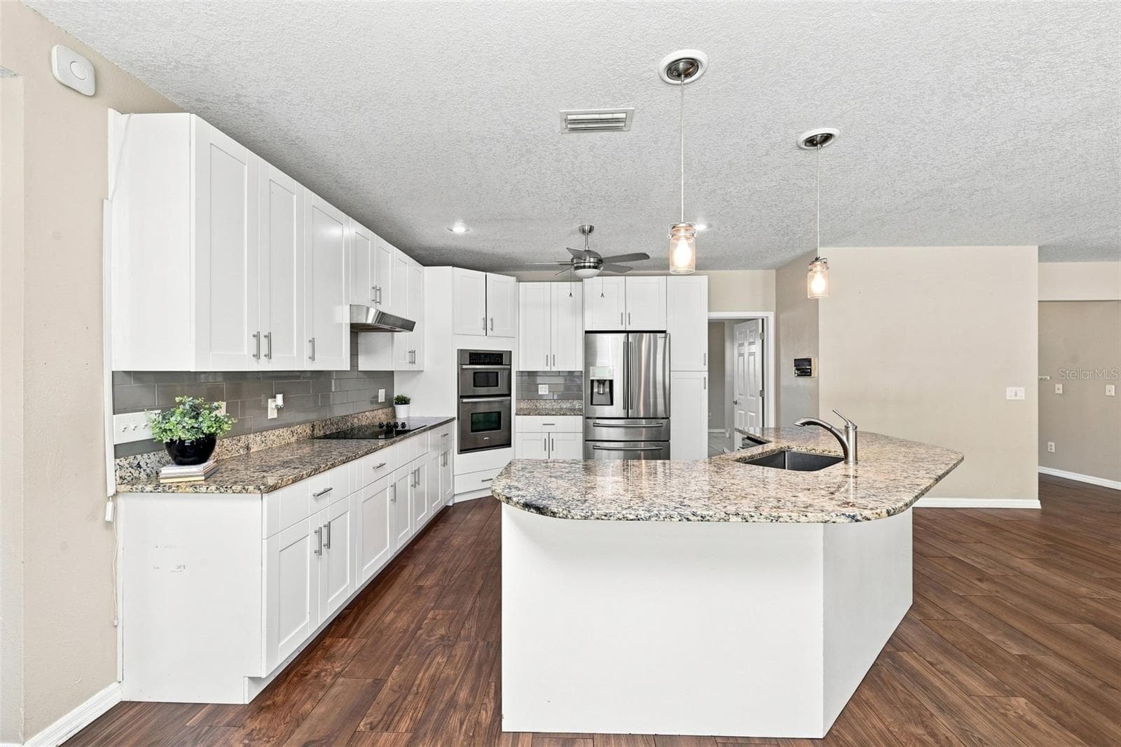 Spacious Kitchen Island & Breakfast Bar provide additional seating and prep space while maintaining an open connection to the family room. - 1349 VALLEY PINE CIR, APOPKA