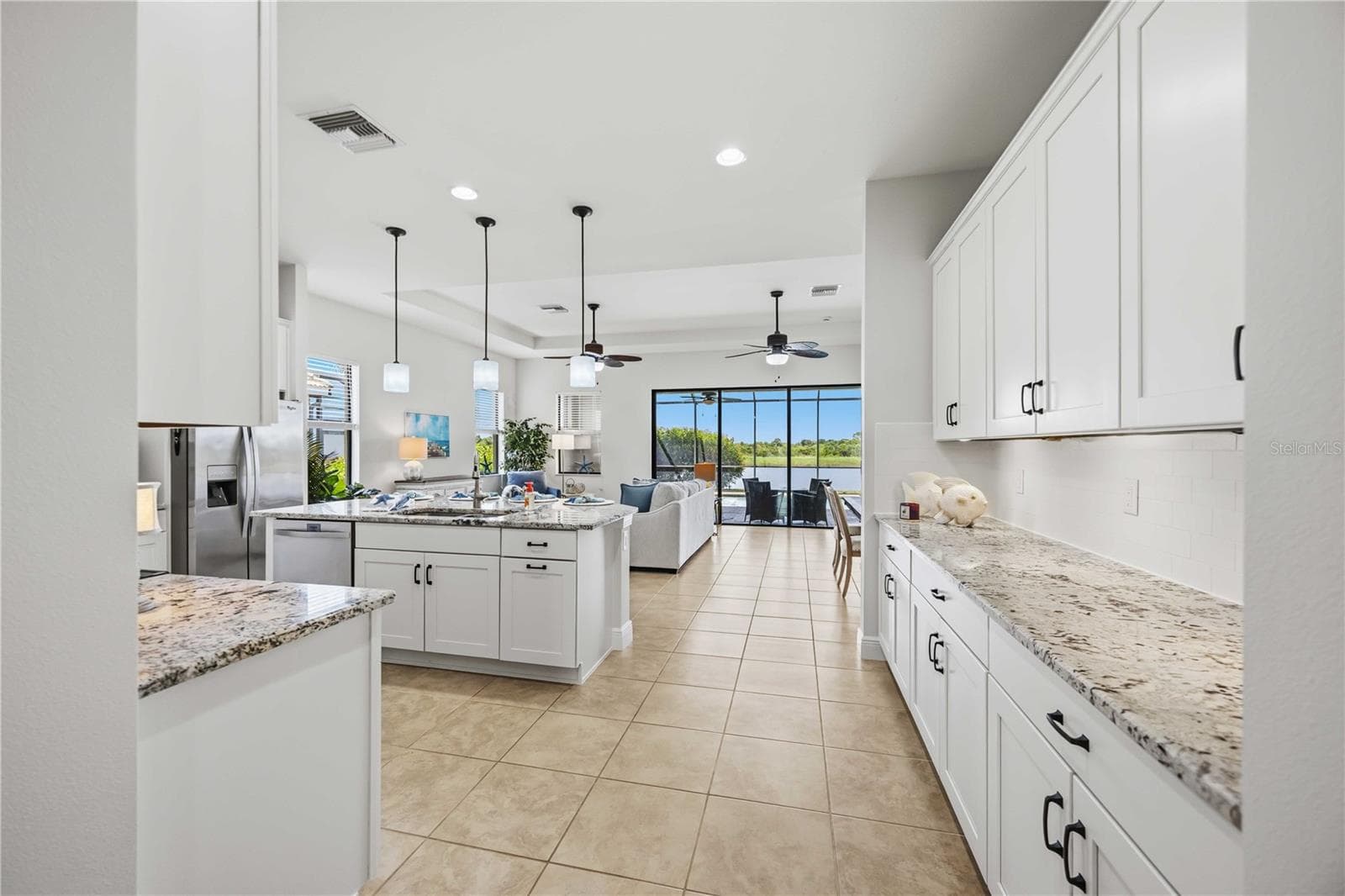 The kitchen is a showpiece - stunning pendant lights, white cabinets and granite counter tops. - 23781 WAVERLY CIR, VENICE