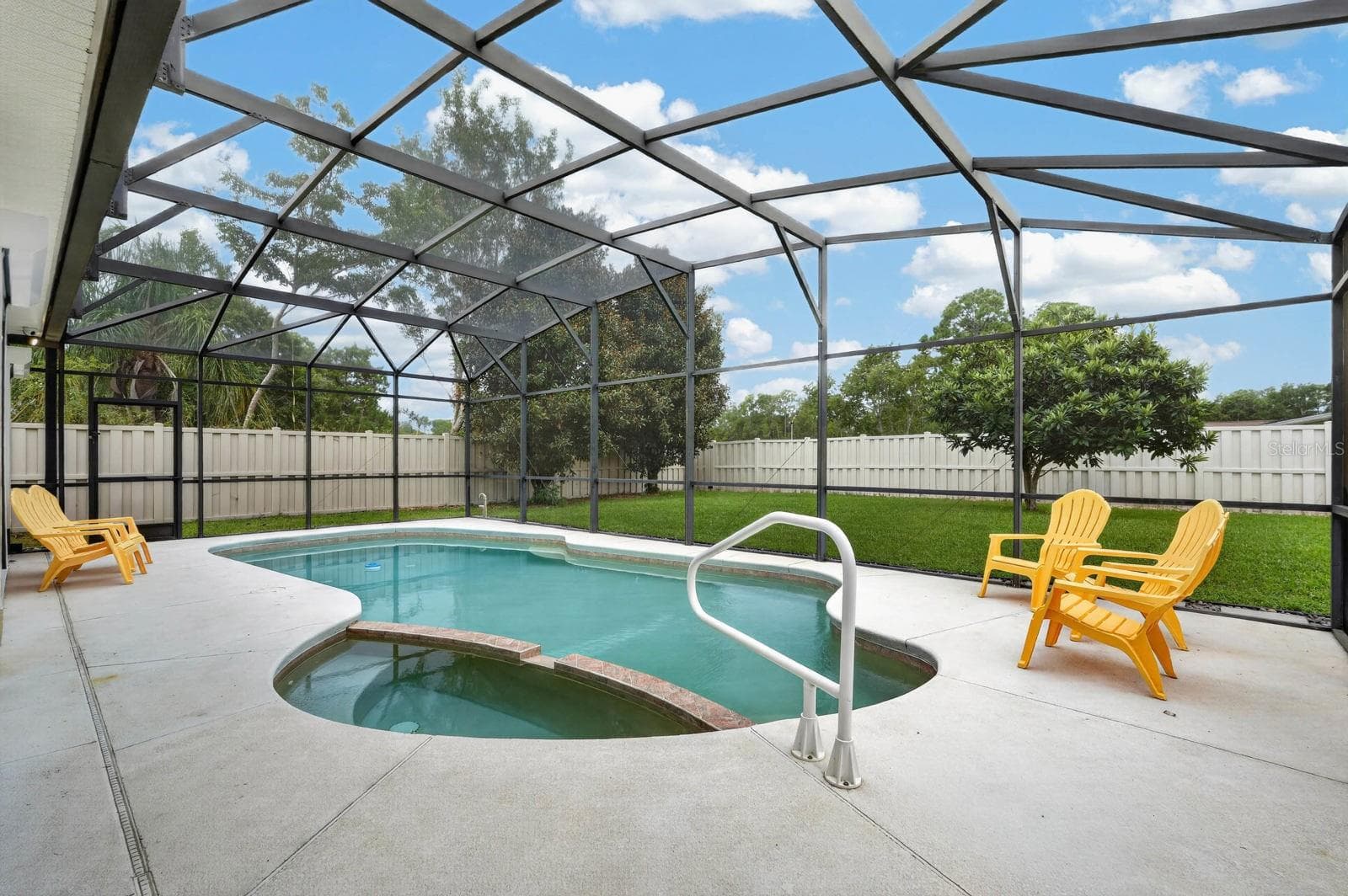 Pool area with covered patio area behind. - 100 FLAMINGO DR, PALM COAST