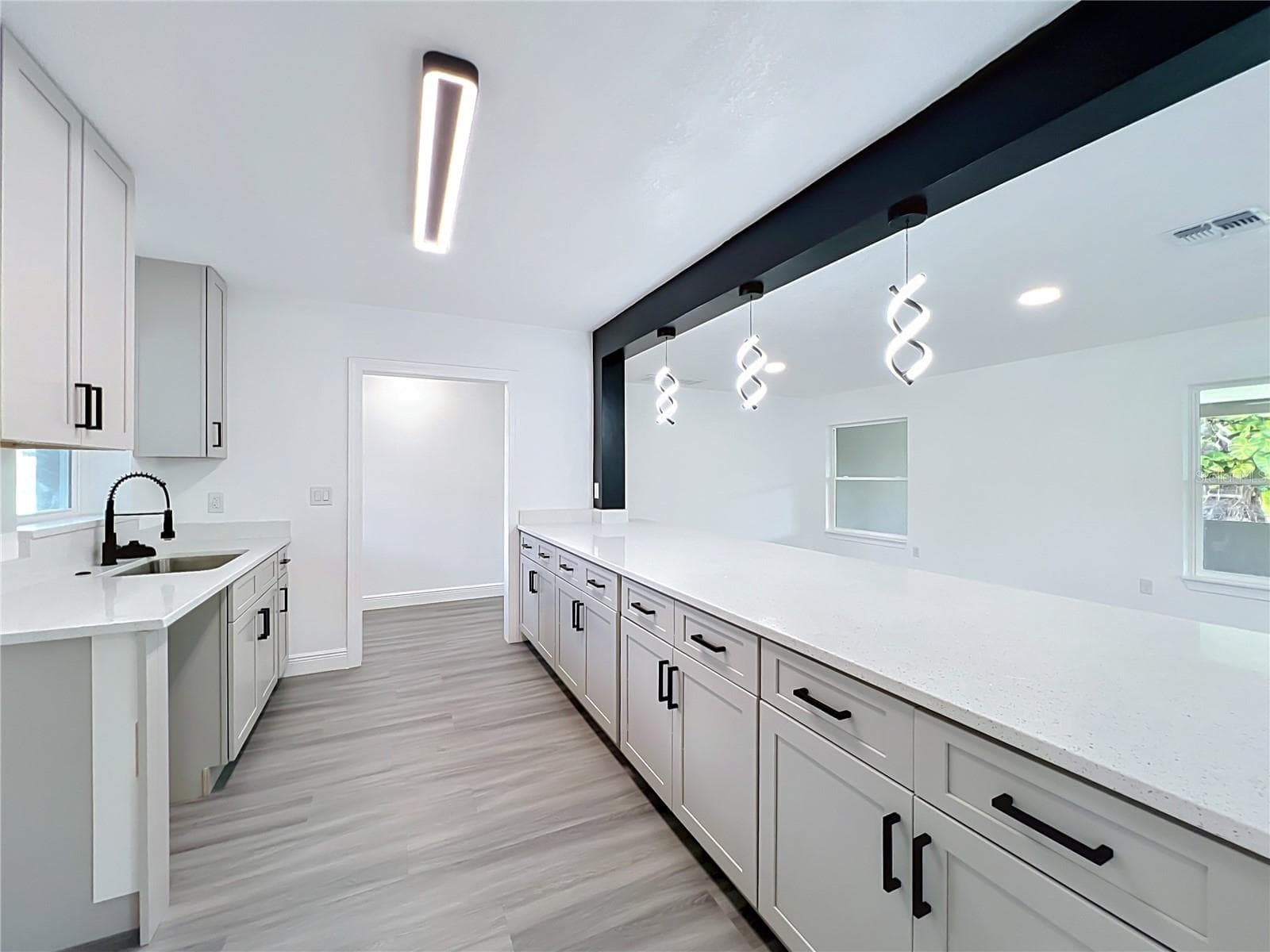 The renovated kitchen offers generous cabinetry, counter space and a modern design. - 3202 TRADEWINDS TRL, ORLANDO
