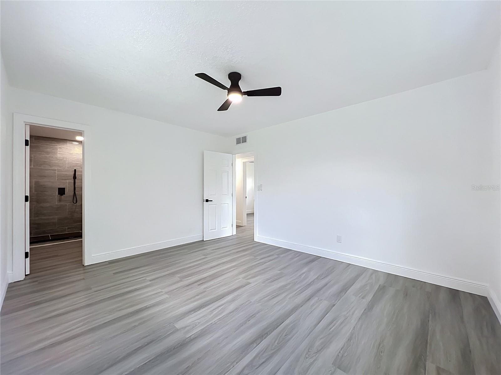 Primary bedroom — approximately 14'8" x 12'5", offering plenty of space for a comfortable private retreat. - 3202 TRADEWINDS TRL, ORLANDO