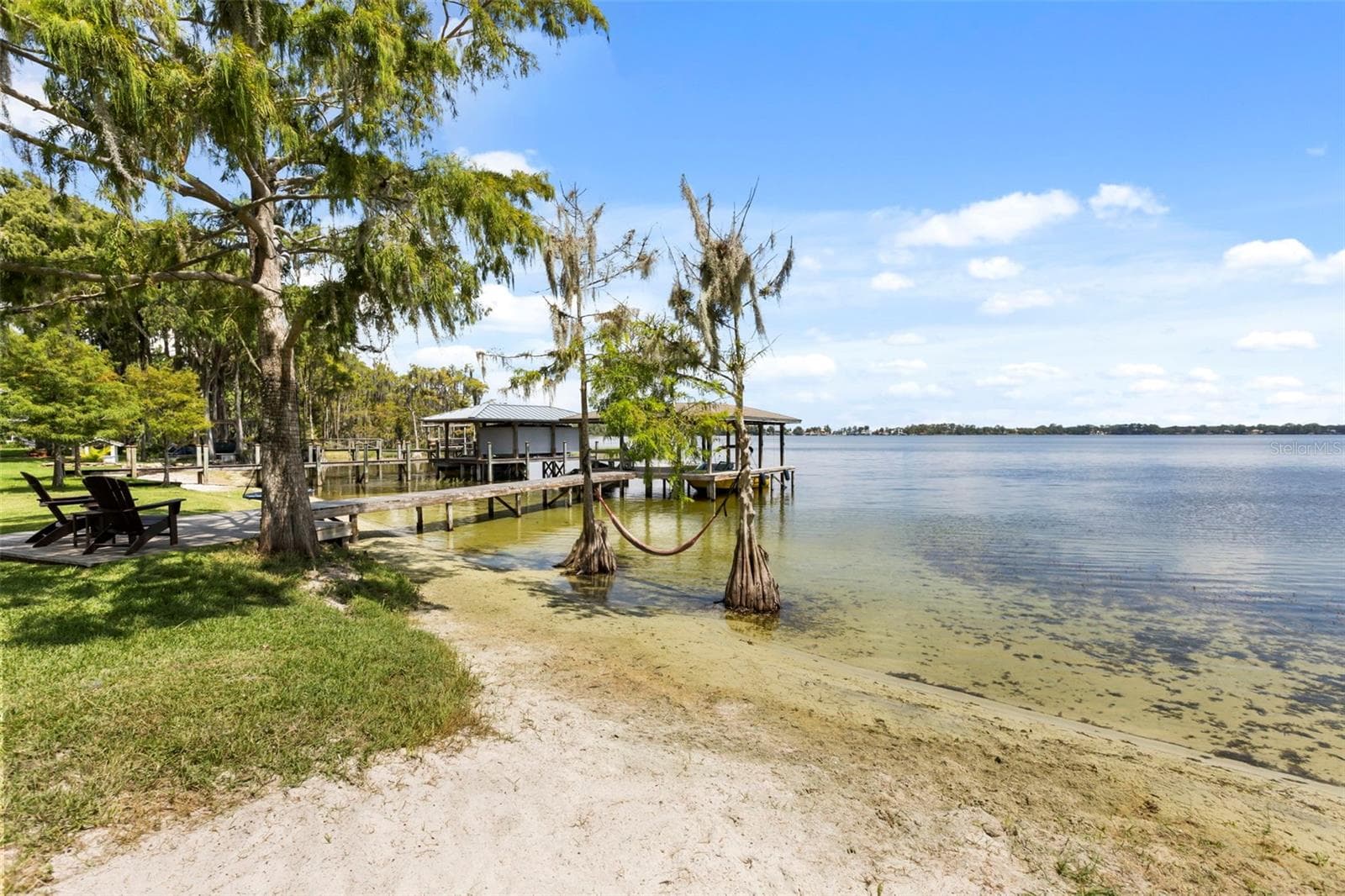 The sandy shoreline with gradual water entry is another exceptional feature, providing an inviting connection to the lake for swimming, paddleboarding, kayaking, and enjoying the water from your own backyard. - 10430 LAKE COTTAGE LN, ORLANDO