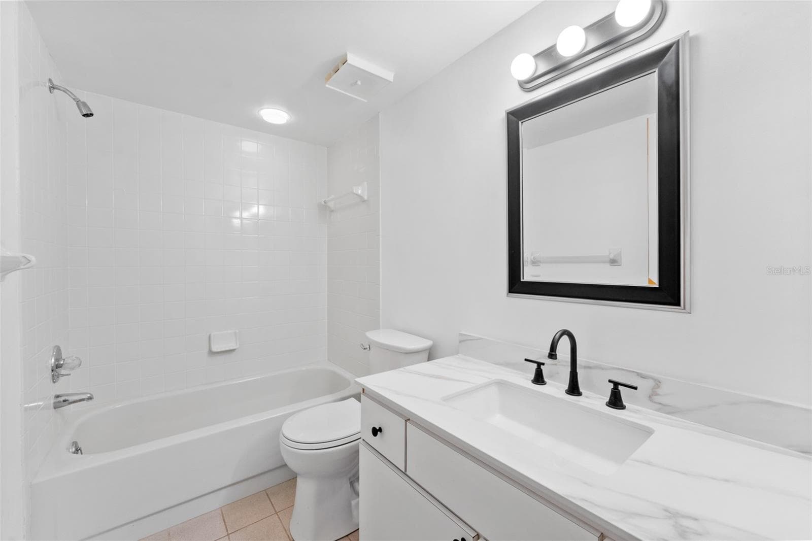 New vanity and toilet in the guest bathroom. - 5400 PARK ST N #511, ST PETERSBURG