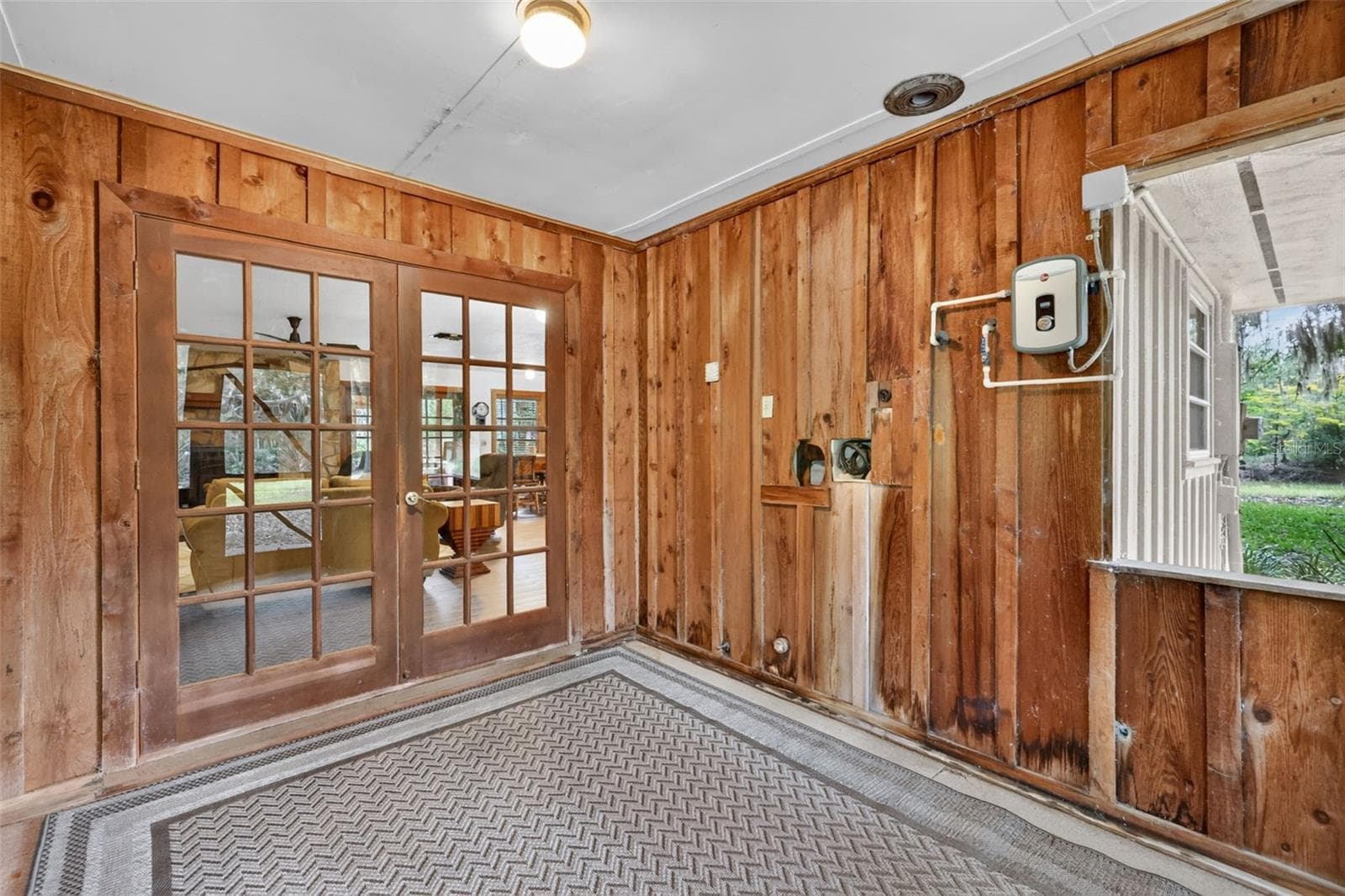 Opposite view from porch back into the house featuring the tankless water heater and laundry hookups - 24939 OLD DEER RD, PAISLEY
