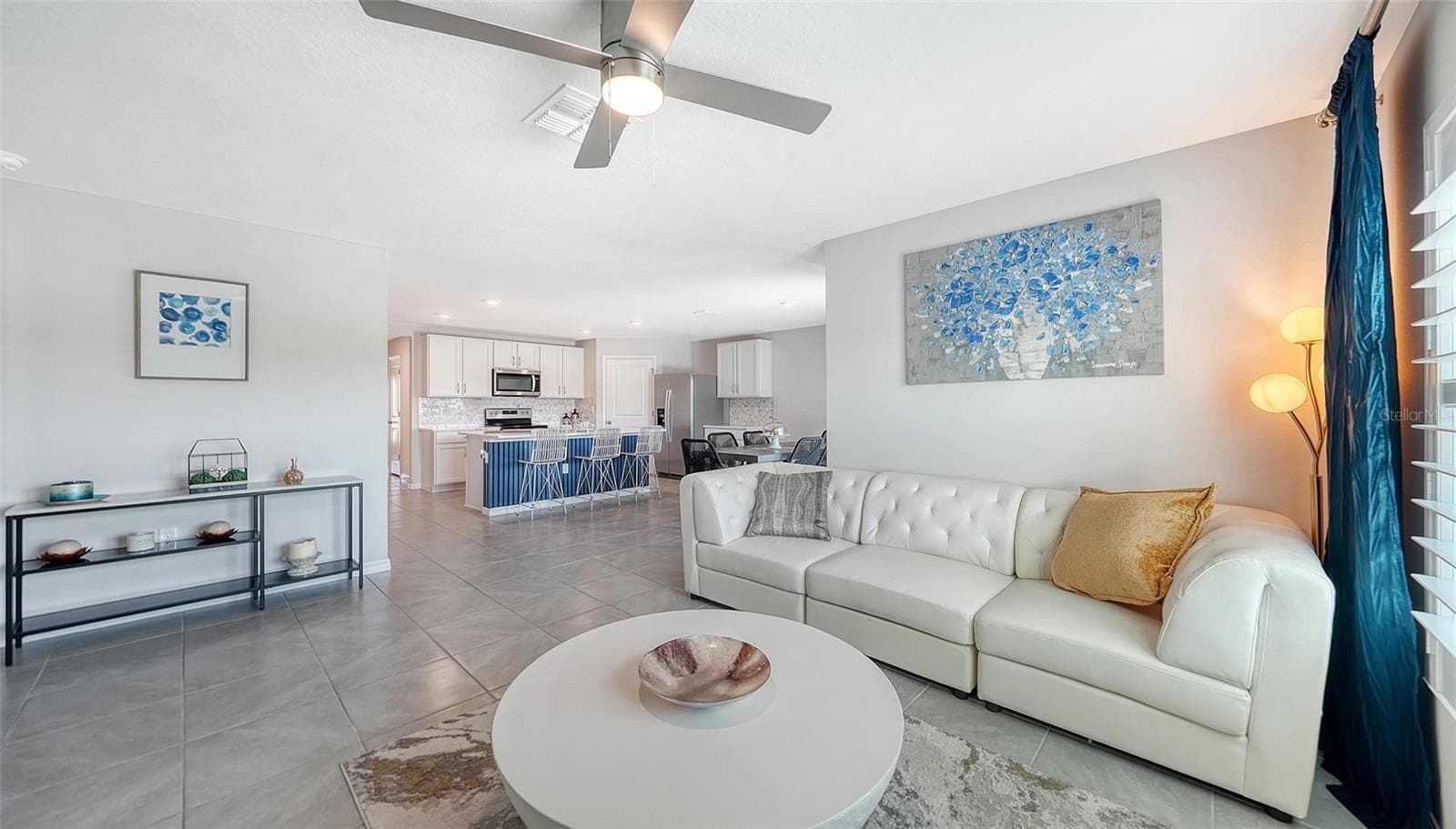 Great room looking into the kitchen with an upgraded ceiling fan. - 10402 CHARLOTTE DR, PARRISH