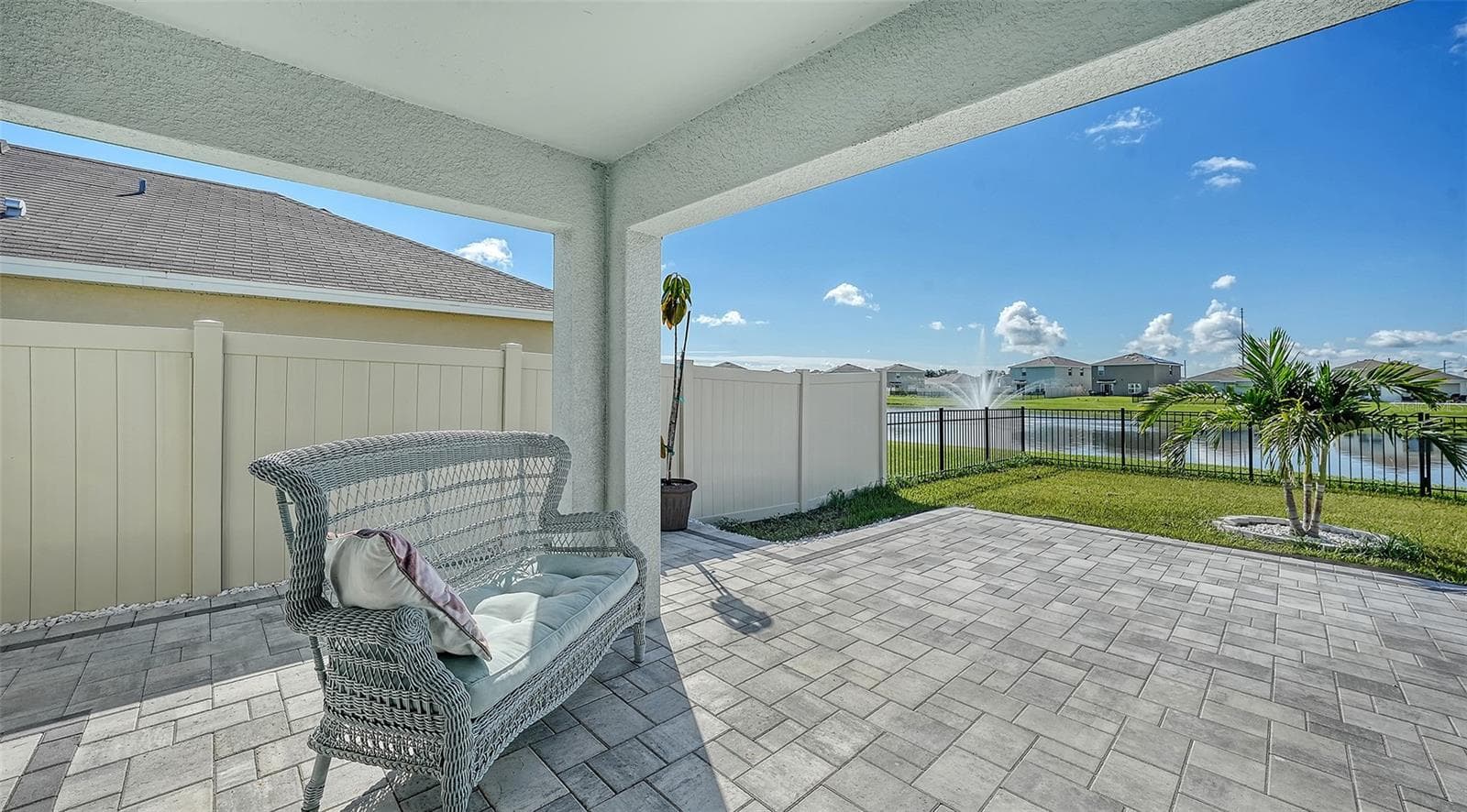 Extended lanai with patio pavers overlooking the fenced in backyard and a pretty view of the pond with a water fountain. - 10402 CHARLOTTE DR, PARRISH