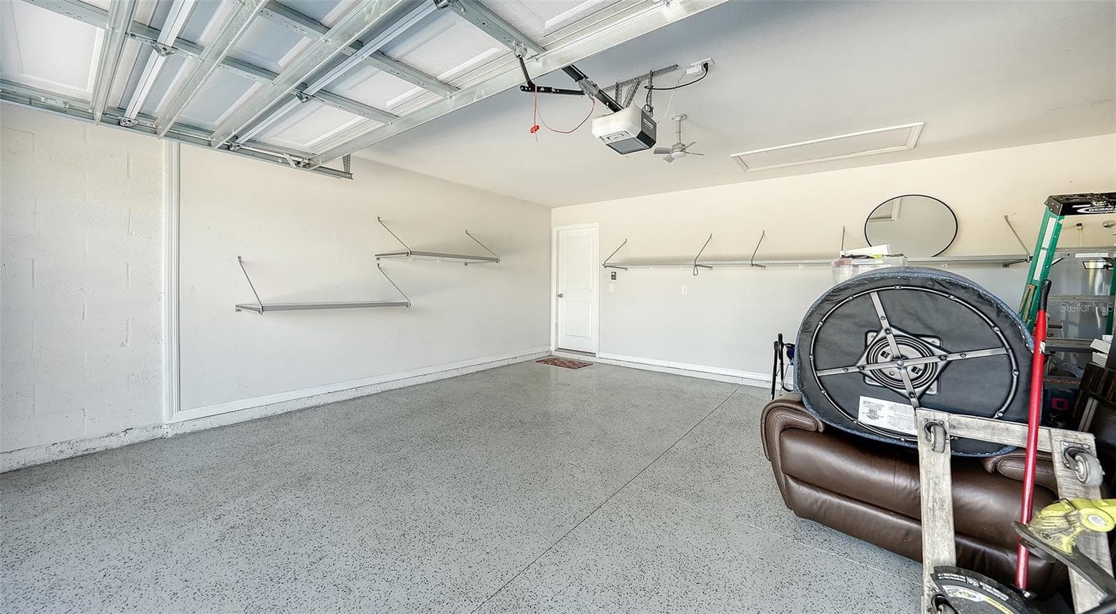 The garage has upgraded epoxy flooring as well as storage racks for your convenience. - 10402 CHARLOTTE DR, PARRISH