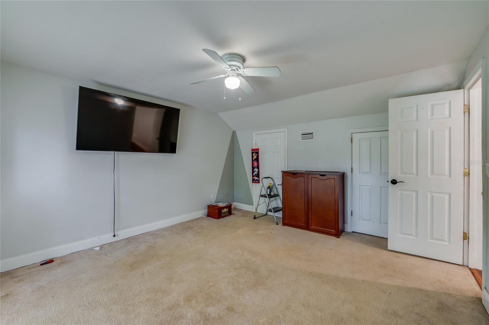 Generous room offering plush carpet flooring, sloped ceiling architecture, and a central ceiling fan. - 2081 PENNSYLVANIA DR, DELAND