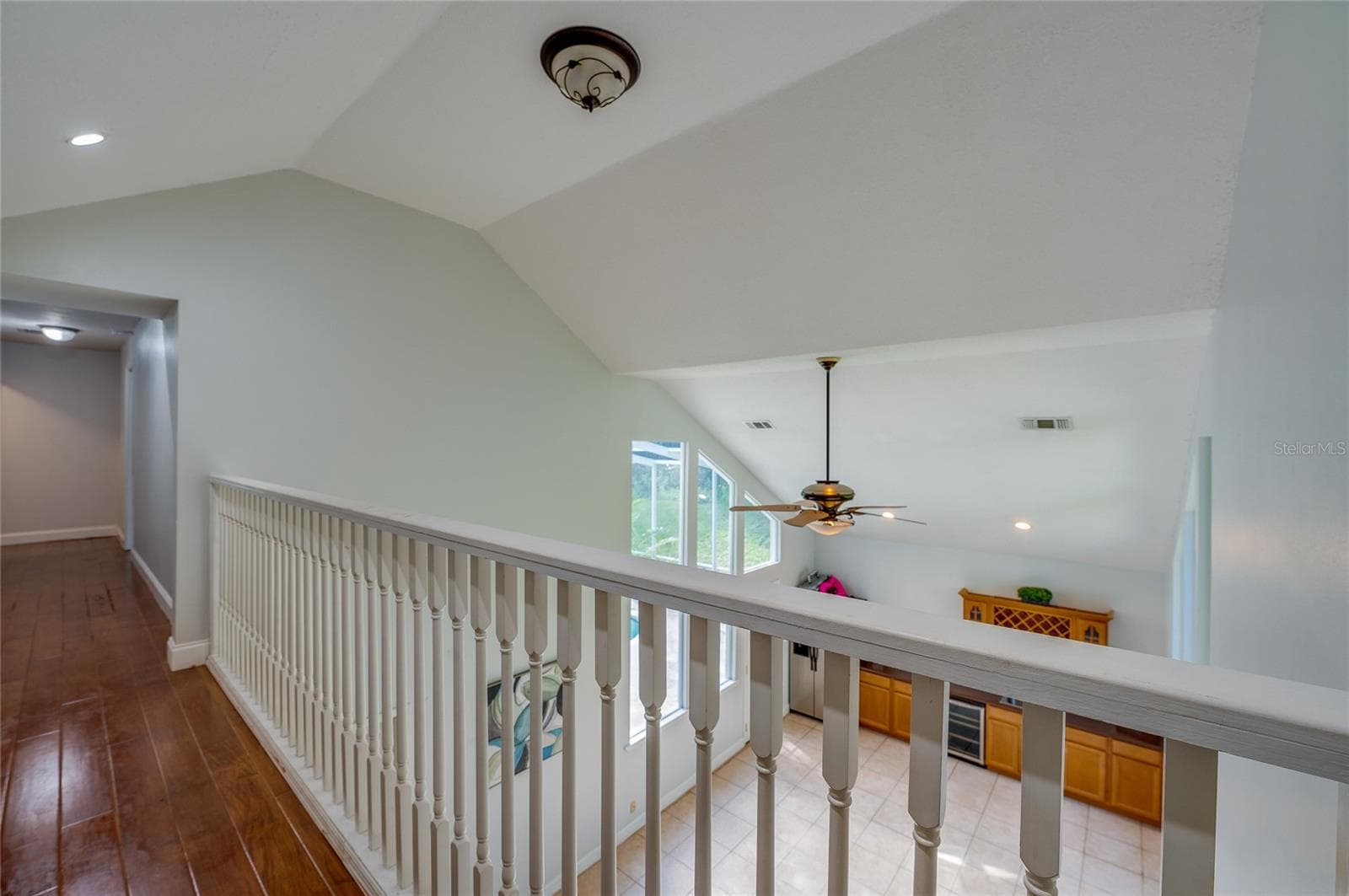 Upper-level hallway overlook featuring white balusters and a clear view down into the vaulted lower living space. - 2081 PENNSYLVANIA DR, DELAND