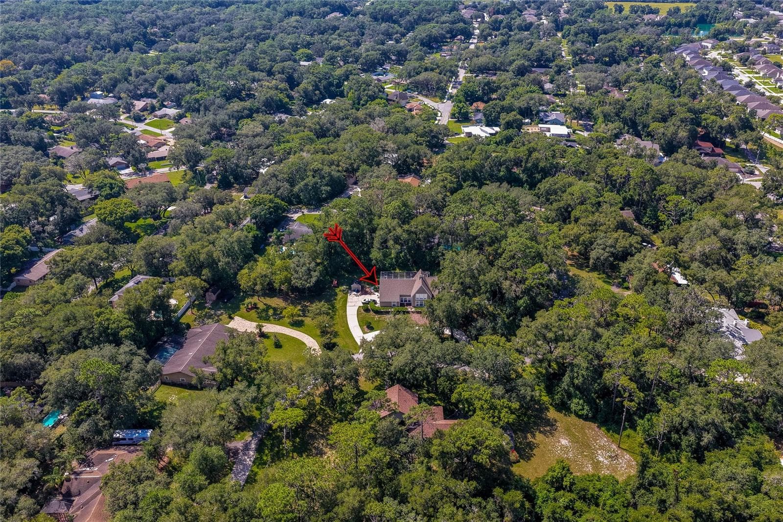 High-altitude aerial shot highlighting the property's location tucked within a lush, tree-filled residential neighborhood. - 2081 PENNSYLVANIA DR, DELAND