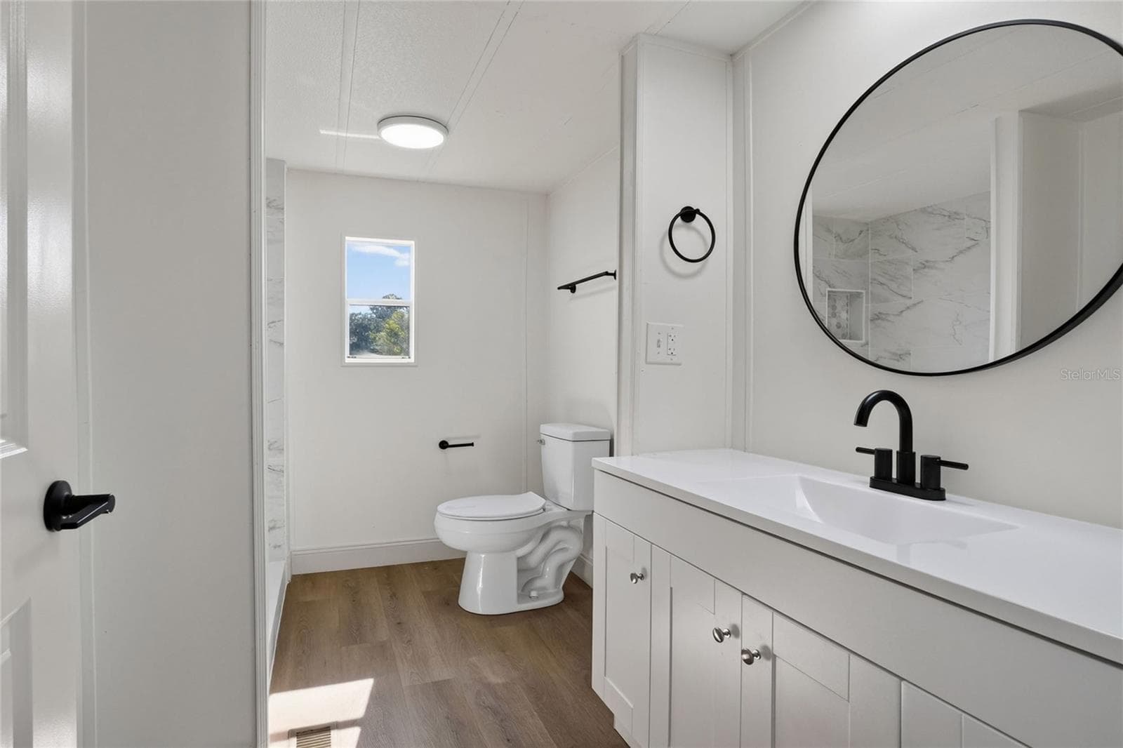Primary Bathroom with porcelain tile shower enclosure, modern vanity, and walk in closet - 2055 S FLORAL AVE #55, BARTOW