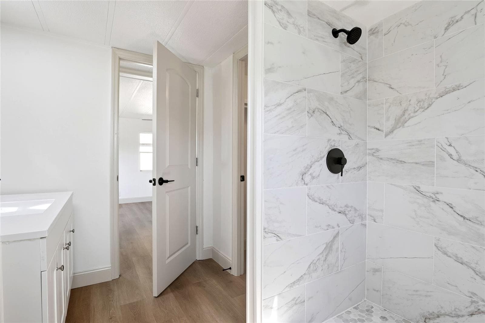 Primary Bathroom with porcelain tile shower enclosure, modern vanity, and walk in closet - 2055 S FLORAL AVE #55, BARTOW