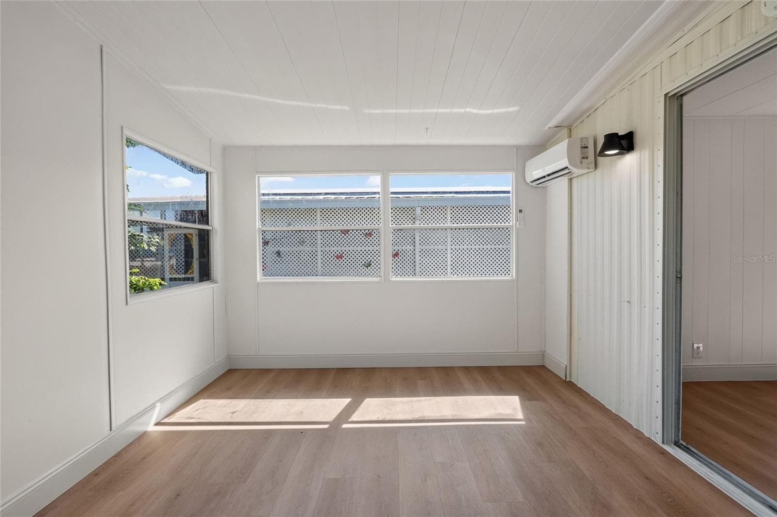 Enclosed Florida Room with new mini-split a/c system and view of the lake and community amenities - 2055 S FLORAL AVE #55, BARTOW