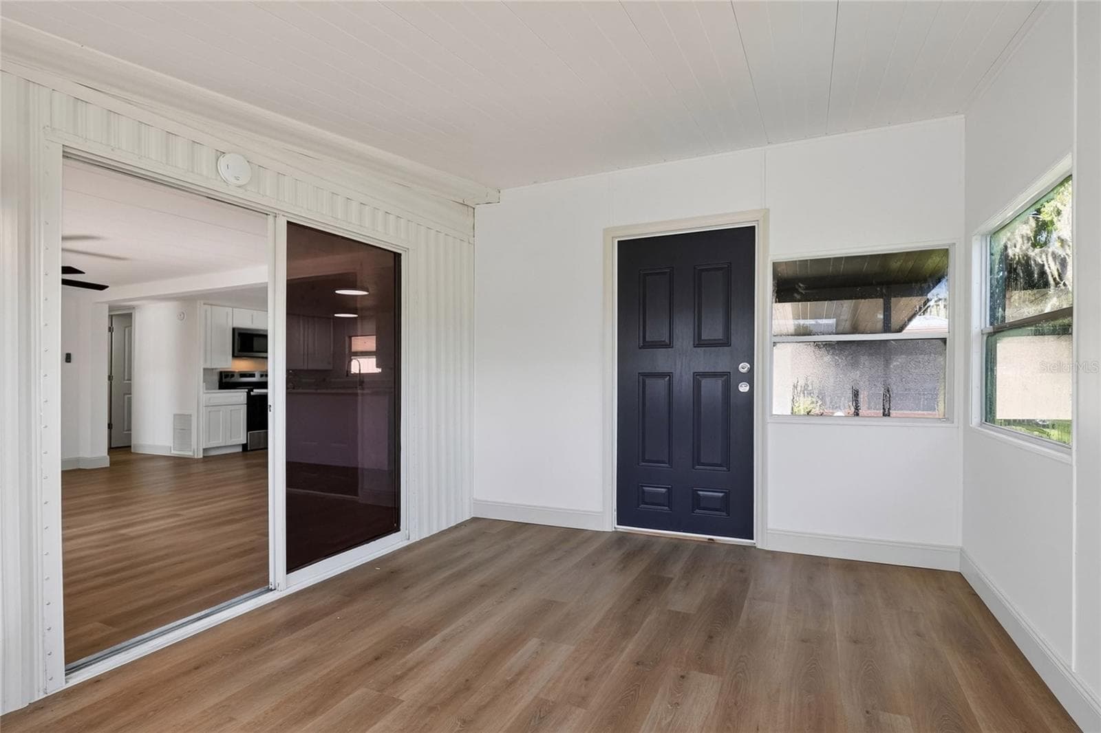 Enclosed Florida Room with new mini-split a/c system and view of the lake and community amenities, opens onto covered patio - 2055 S FLORAL AVE #55, BARTOW