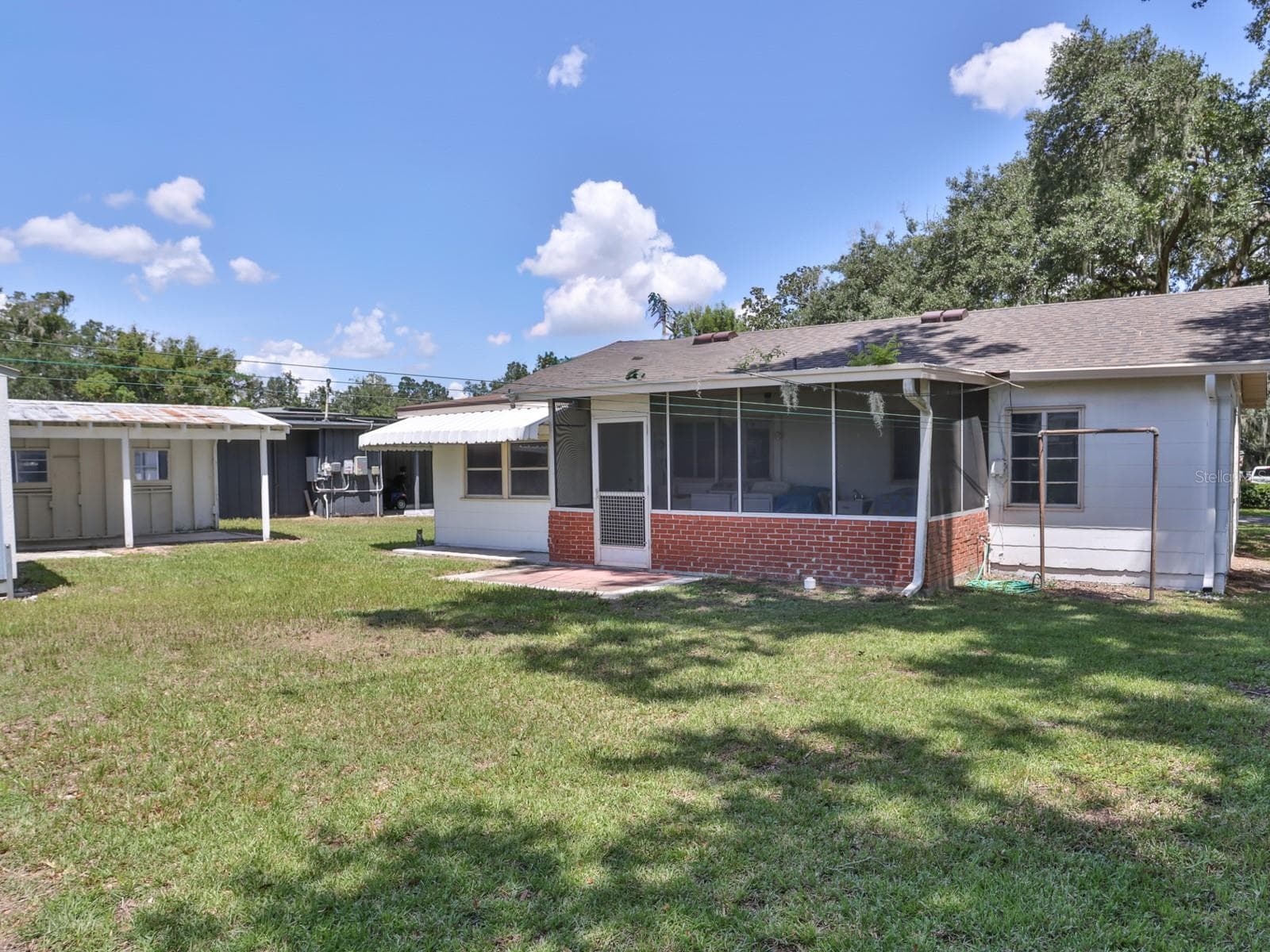 Back of the home with view of the one car carport. - 1855 E VALENCIA DR, BARTOW