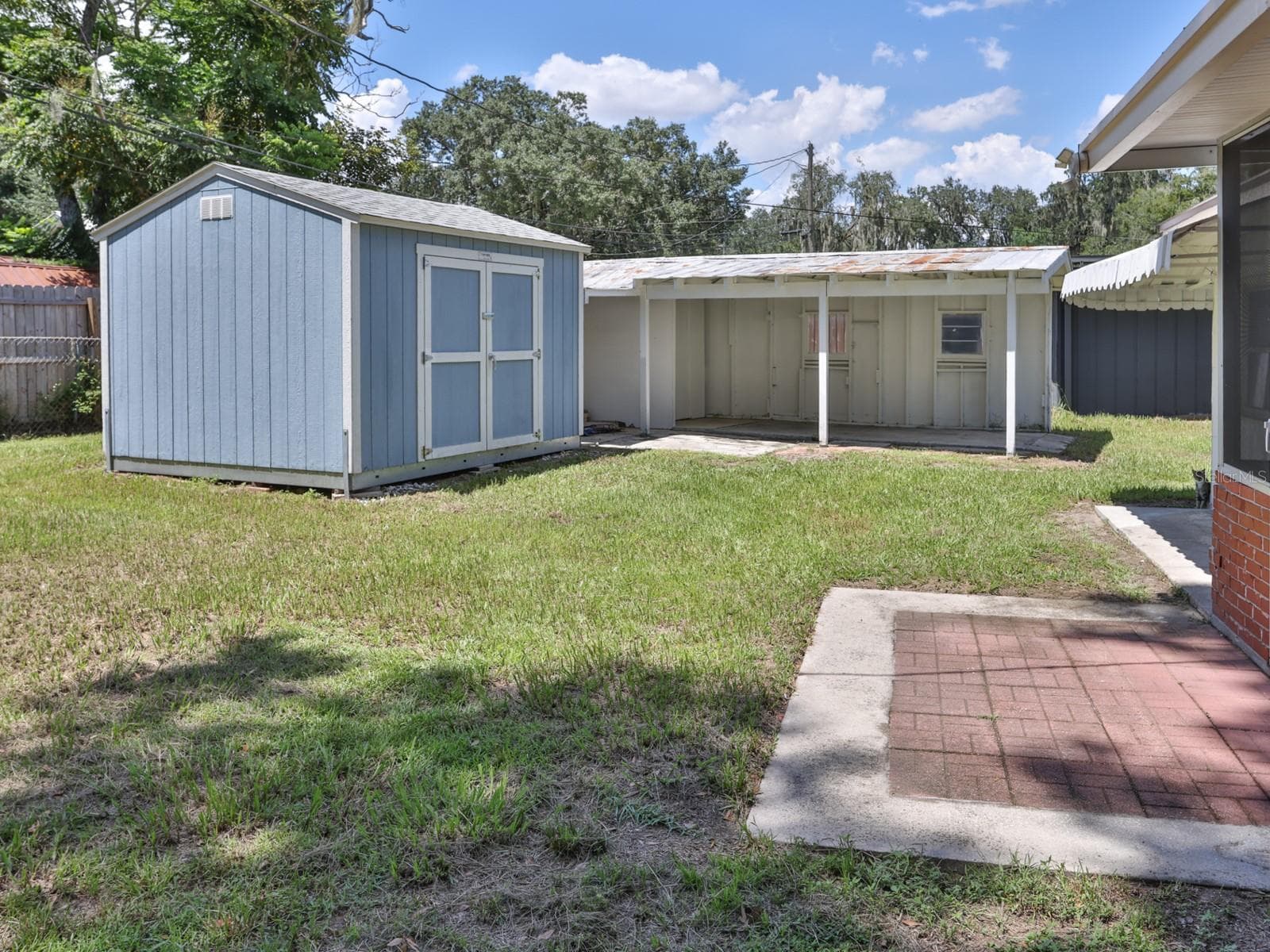Back yard. With view of one car carport and shed. - 1855 E VALENCIA DR, BARTOW