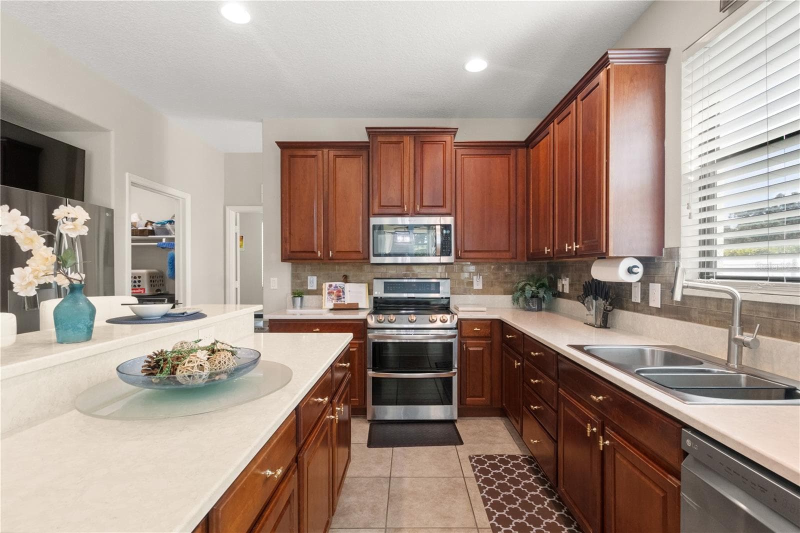 The kitchen features elegant warm wood countertops with white quartz counter tops - 5824 FISH CROW PL, LAND O LAKES