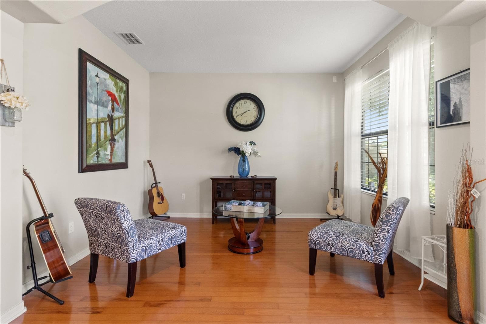 To the right as you enter is the formal living area which is bathed in natural light and has hardwood floors underneath - 5824 FISH CROW PL, LAND O LAKES