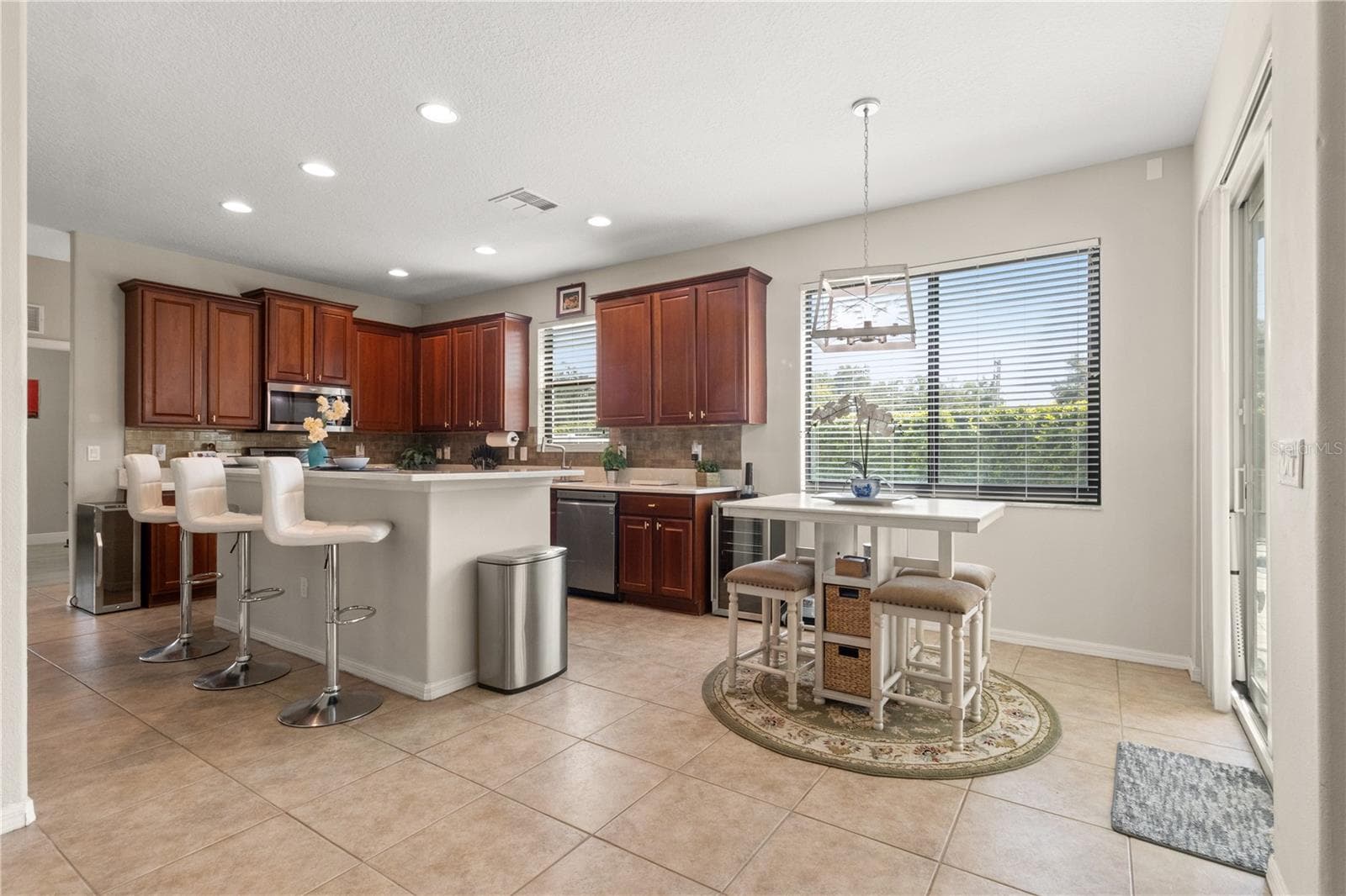 The kitchen is bright and sunny with a breakfast bar and and eating area in the kitchen - 5824 FISH CROW PL, LAND O LAKES