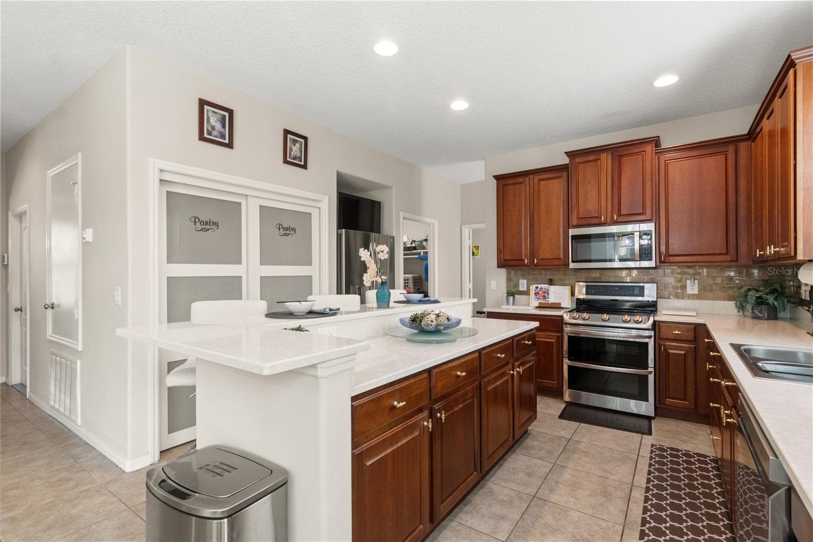 there is a large double doored pantry in the kitchen - 5824 FISH CROW PL, LAND O LAKES
