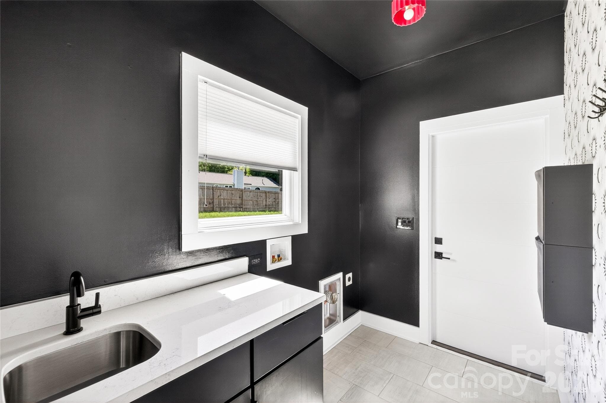 Main level laundry with sink and cabinet. - 5044 Double Lakes Drive, Charlotte