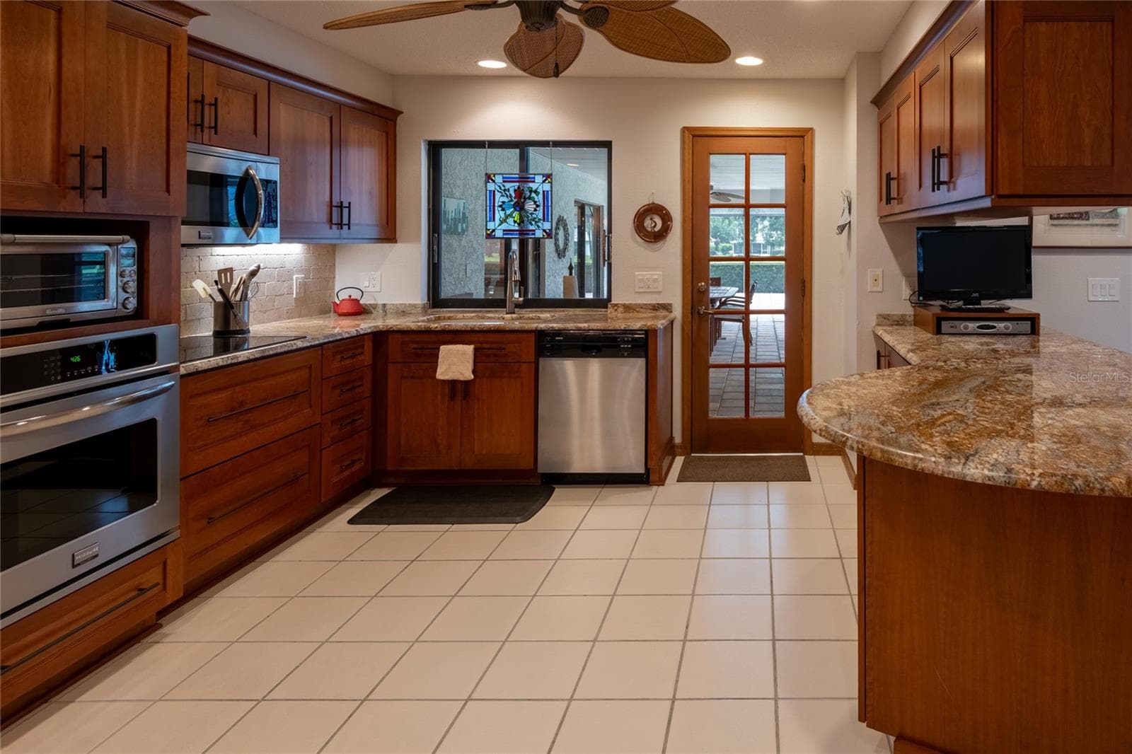 Gorgeous kitchen with a serve through slide window going out to the expansive pool area - 16509 E COURSE DR, TAMPA