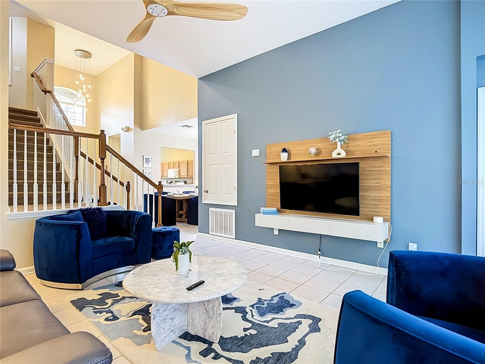 Living room featuring soaring ceilings and an open-concept design. - 7742 COMROW ST, KISSIMMEE