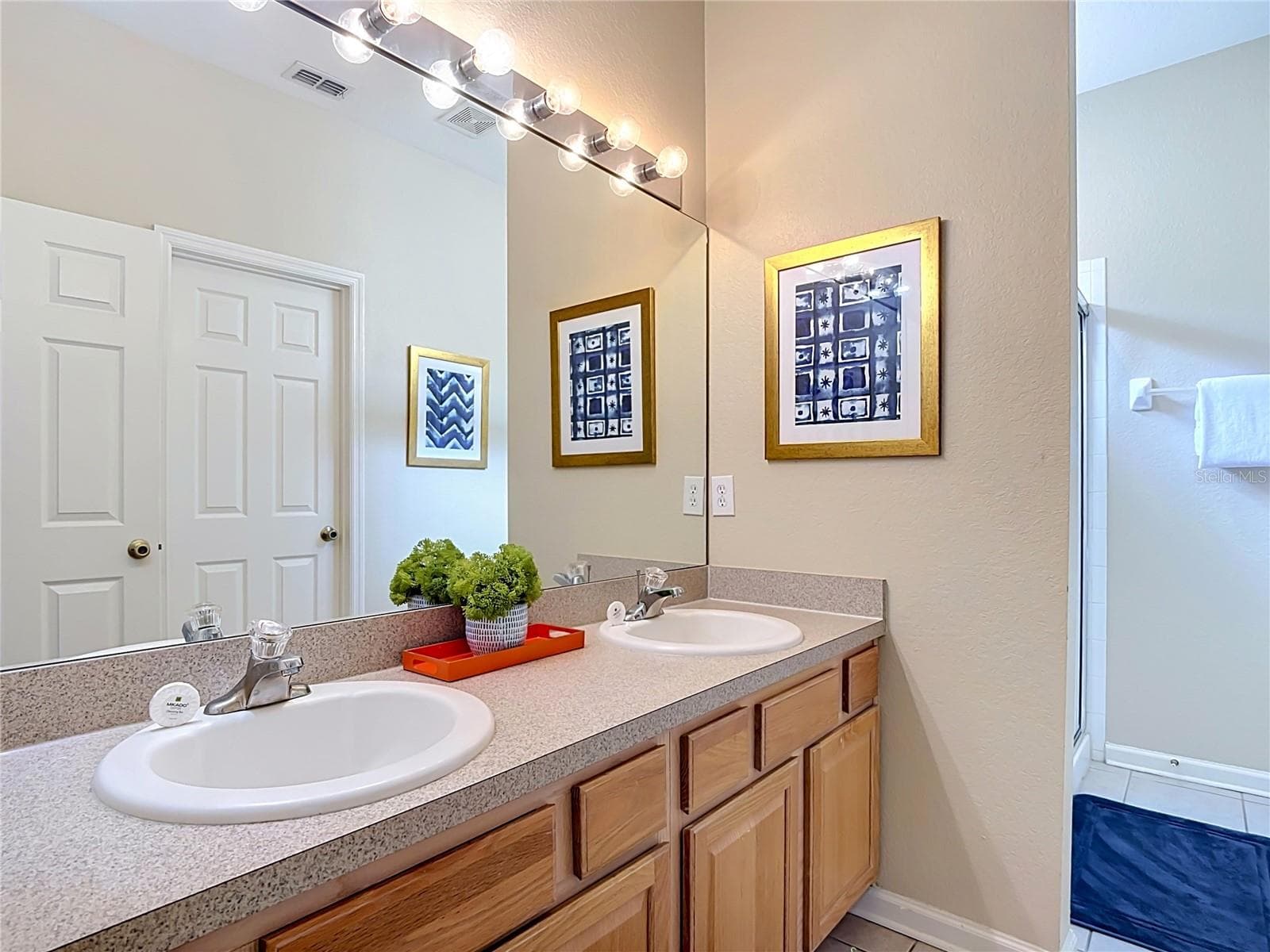 Ensuite bathroom featuring dual vanities, a soaking tub, and separate shower. - 7742 COMROW ST, KISSIMMEE