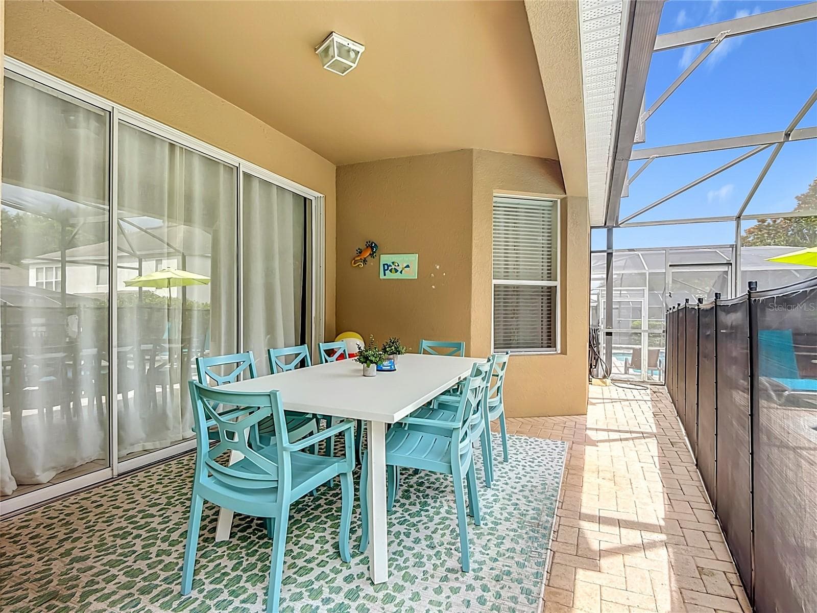 Covered lanai with outdoor dining overlooking the private screened pool and spa. - 7742 COMROW ST, KISSIMMEE