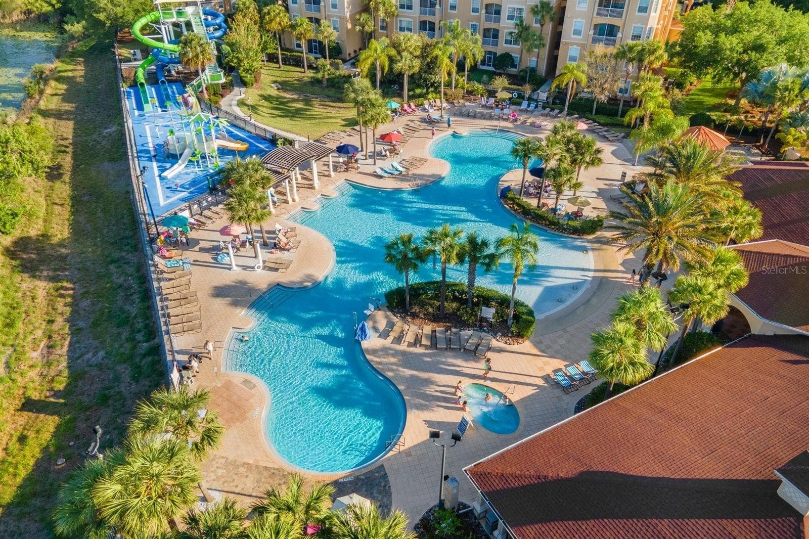 Resort-style lagoon pool with water features and tropical landscaping. - 7742 COMROW ST, KISSIMMEE