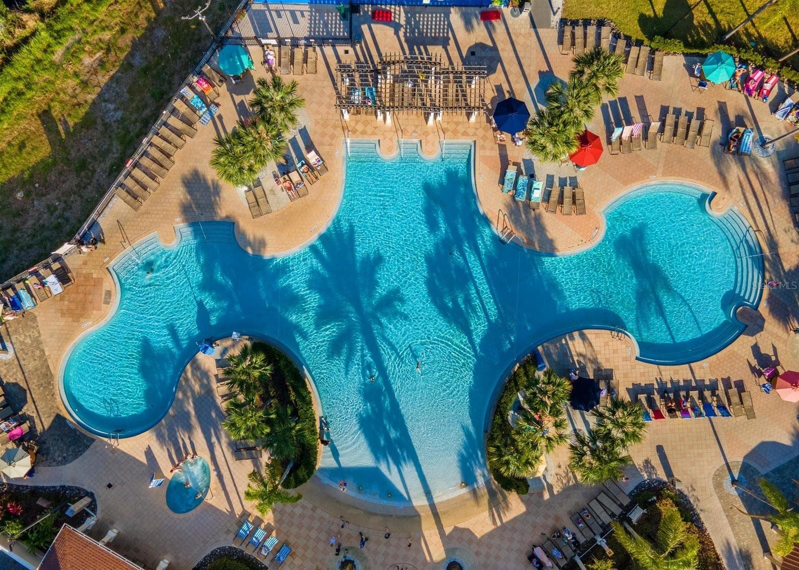 Expansive zero-entry resort pool with plenty of lounge seating. - 7742 COMROW ST, KISSIMMEE