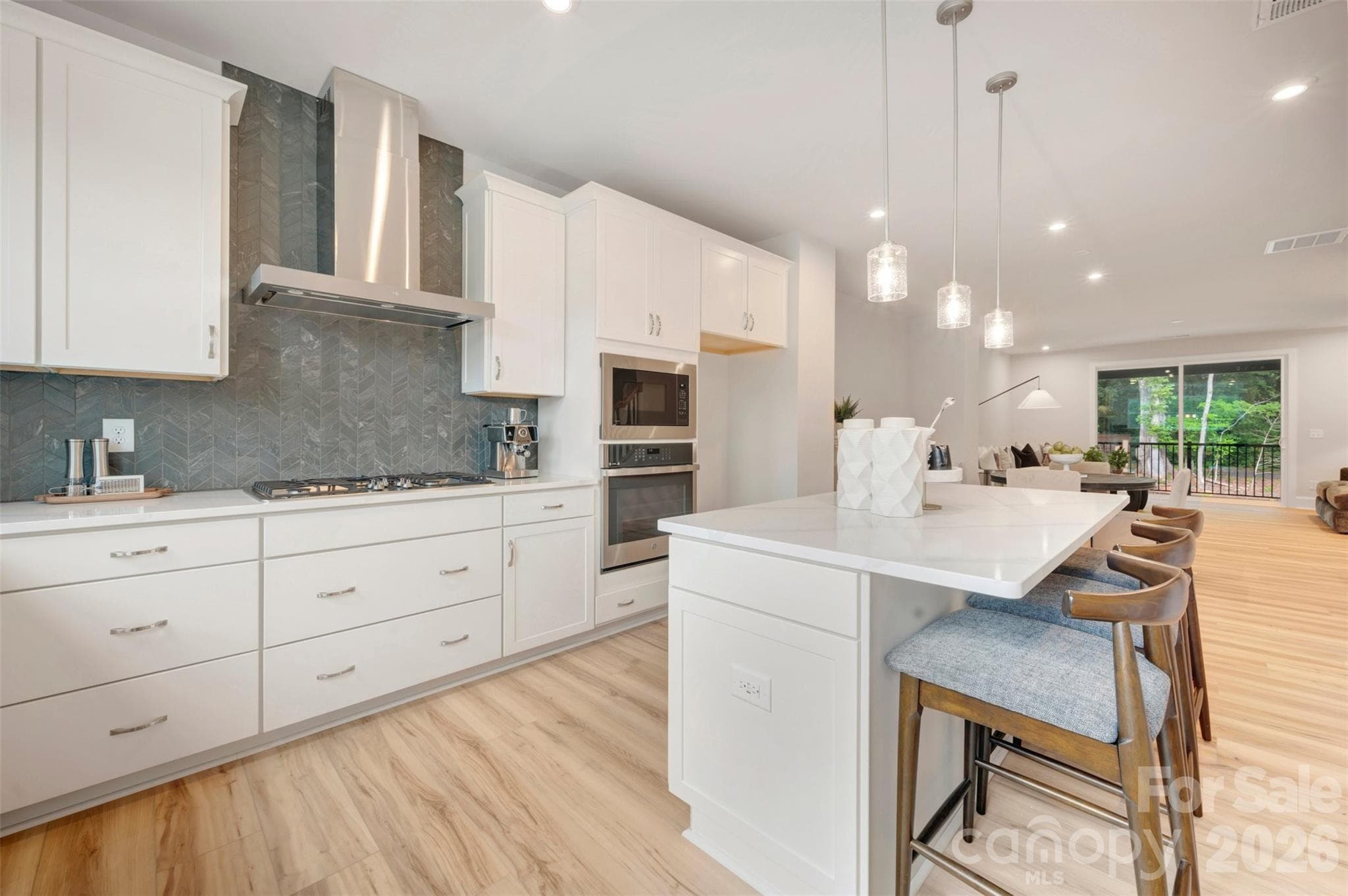 Gourmet kitchen with a gas cooktop and a Designer Style Hood in Stainless Steel - 309 Old Town Village Road, Waxhaw