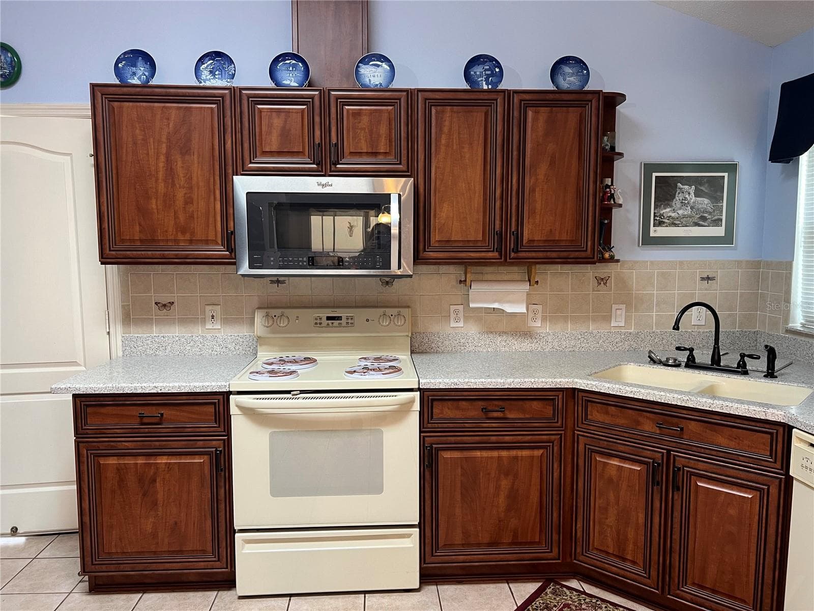 Kitchen with Range, Microwave with vent, tall ceiling, solid surface countertops, tile backsplash and tall ceilings - 1842 PUERTO BELLO DR, THE VILLAGES