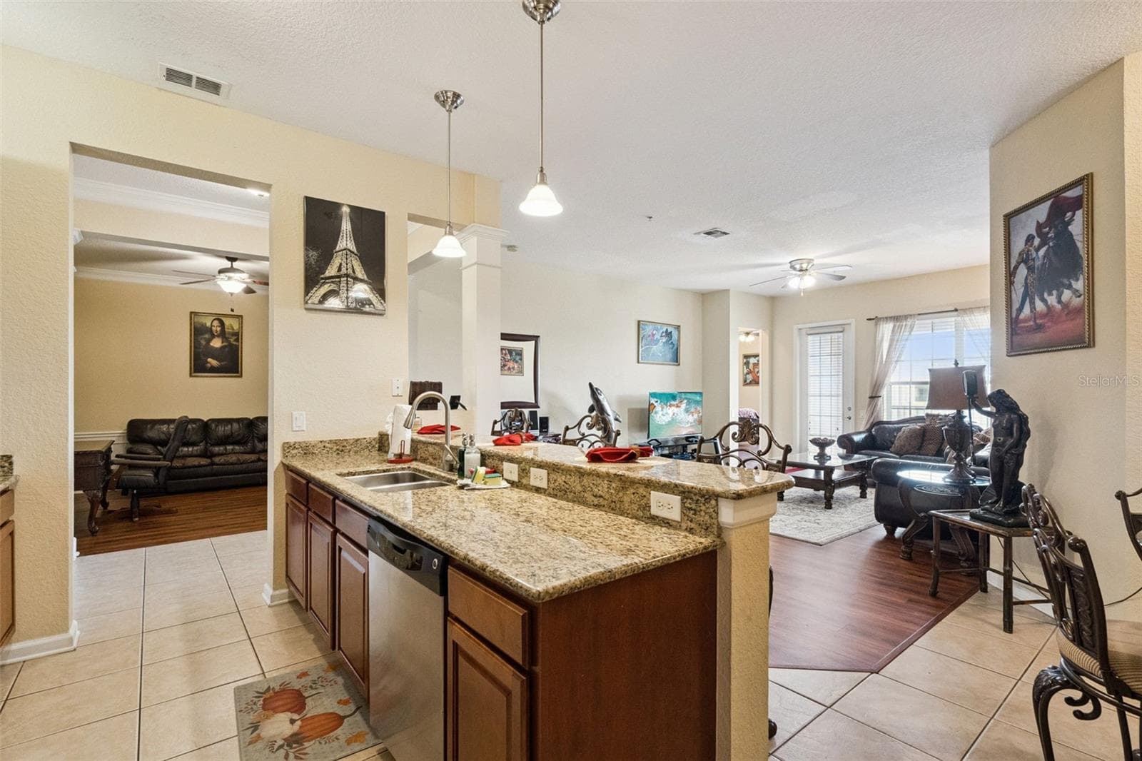 Kitchen & Breakfast Bar:Functional kitchen layout boasting raised granite breakfast bar, pendant lighting, stainless steel dishwasher, and open views into the living space. - 4840 CAYVIEW AVE #405, ORLANDO
