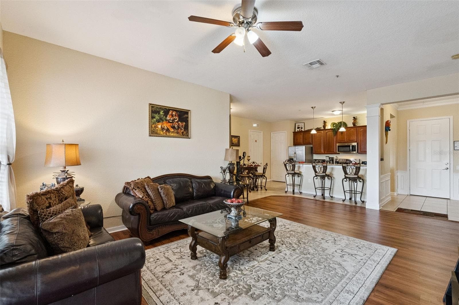 Open-Concept Main Living:Expansive open floor plan seamlessly integrating the living room, raised breakfast bar, kitchen, and entryway. - 4840 CAYVIEW AVE #405, ORLANDO