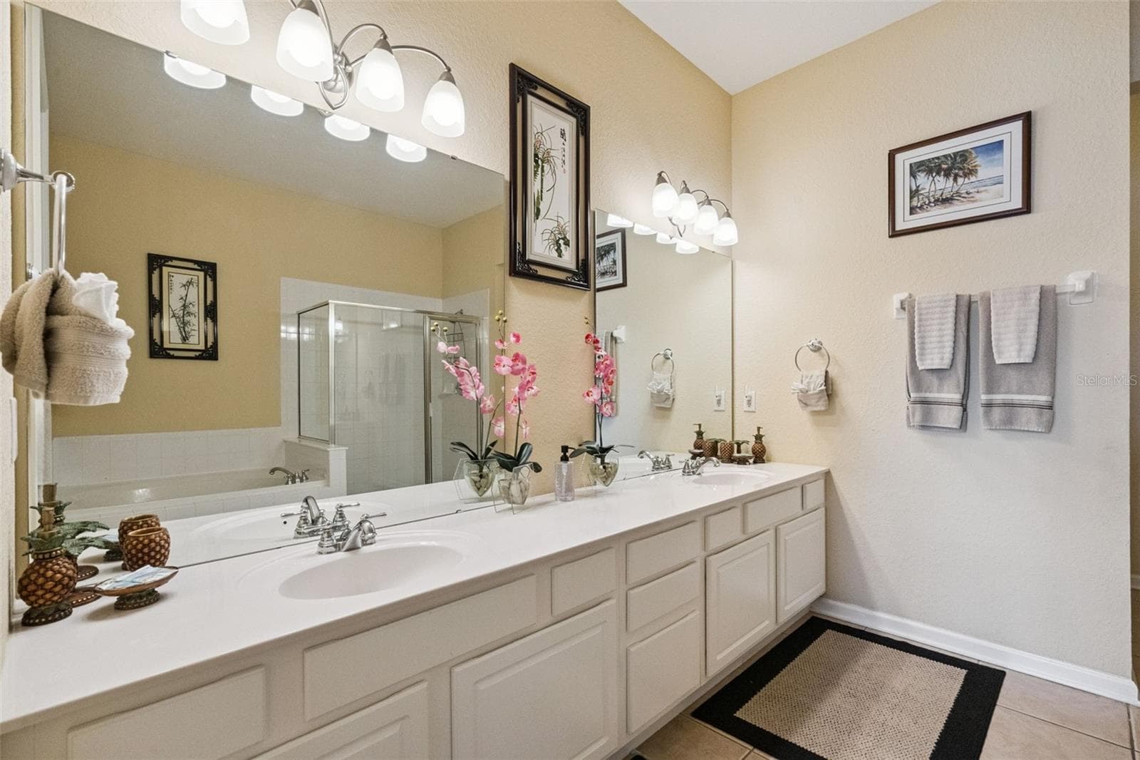 Primary Bath Double Vanity:Primary en-suite bathroom showcasing an expansive double-sink vanity, crisp white cabinetry, generous counter space, large mirror, and tiled flooring. - 4840 CAYVIEW AVE #405, ORLANDO