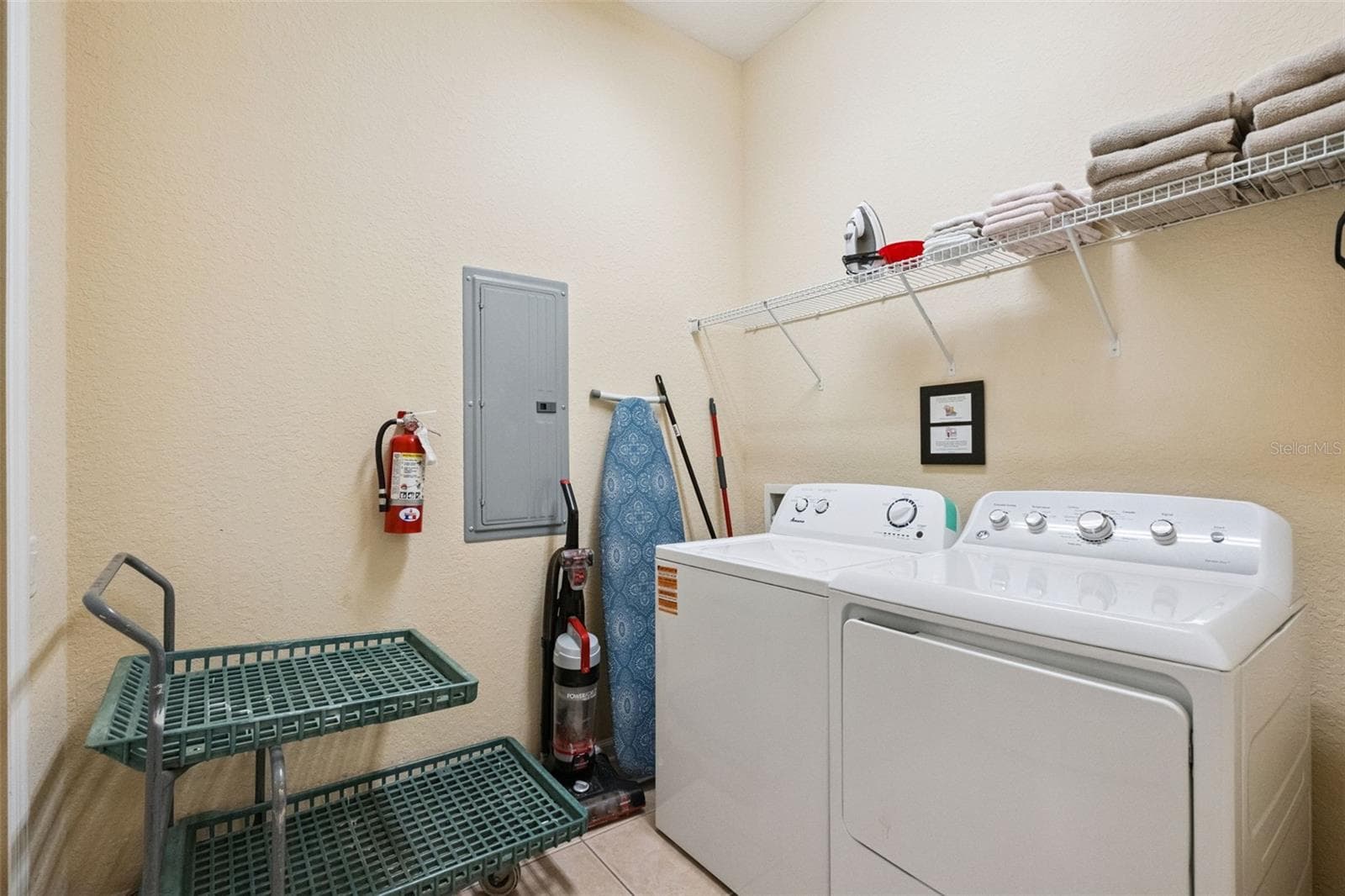 Utility Laundry Room:Functional utility space showcasing washer and dryer hookups, wire linen storage shelving, and room for extra storage or cleaning equipment. - 4840 CAYVIEW AVE #405, ORLANDO